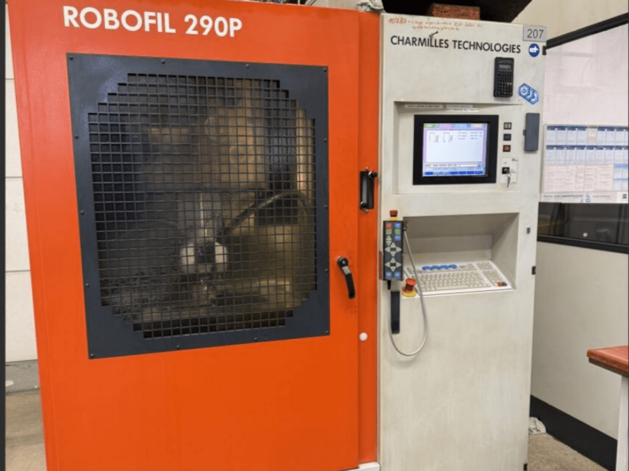 Вид спереду електроерозійного дротяного верстата Robofil 290P компанії CHARMILLES TECHNOLOGIES з панеллю керування та захищеною сіткою робочою зоною.