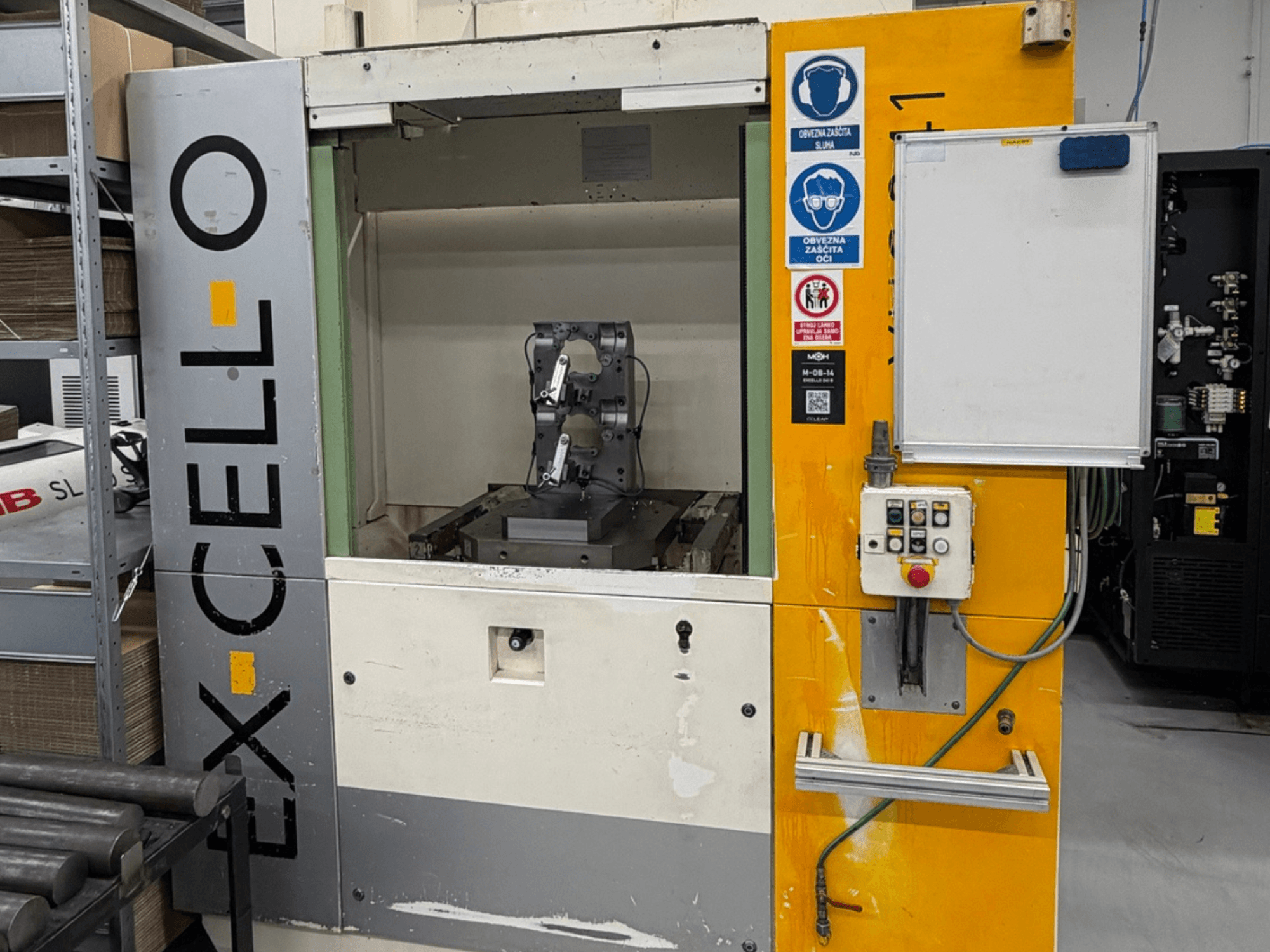 Вид спереду горизонтального обробного центру EXCELLO XHC 241 M/3 з видимою панеллю керування та внутрішньою частиною верстата.
