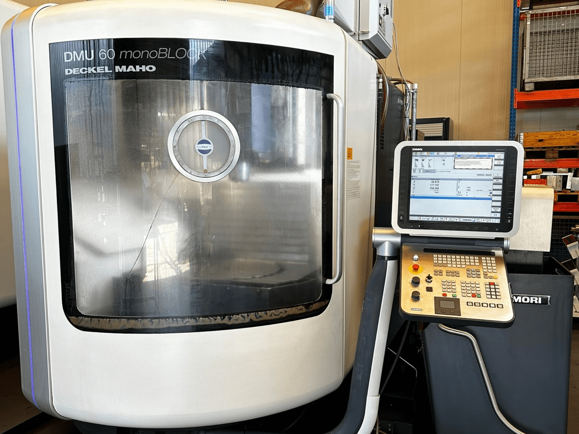 Вертикальний обробний центр DMG MORI DMU 60 monoBLOCK, вид спереду, з сенсорною панеллю керування та світловідбиваючим вікном.