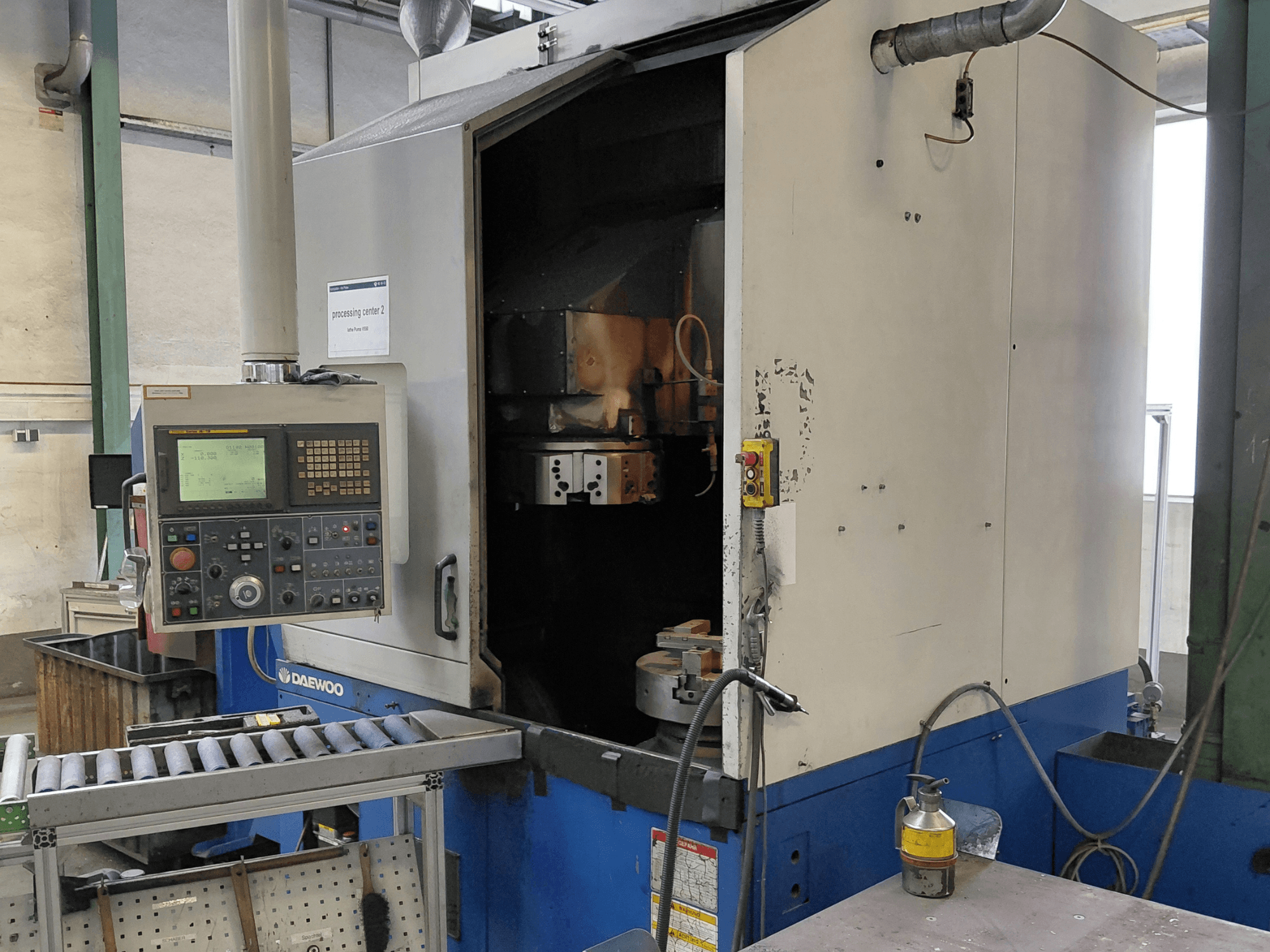 Вертикальний токарний верстат Daewoo Puma V550, вид спереду: панель керування, шпиндель і патрубок для подачі охолоджувальної рідини.