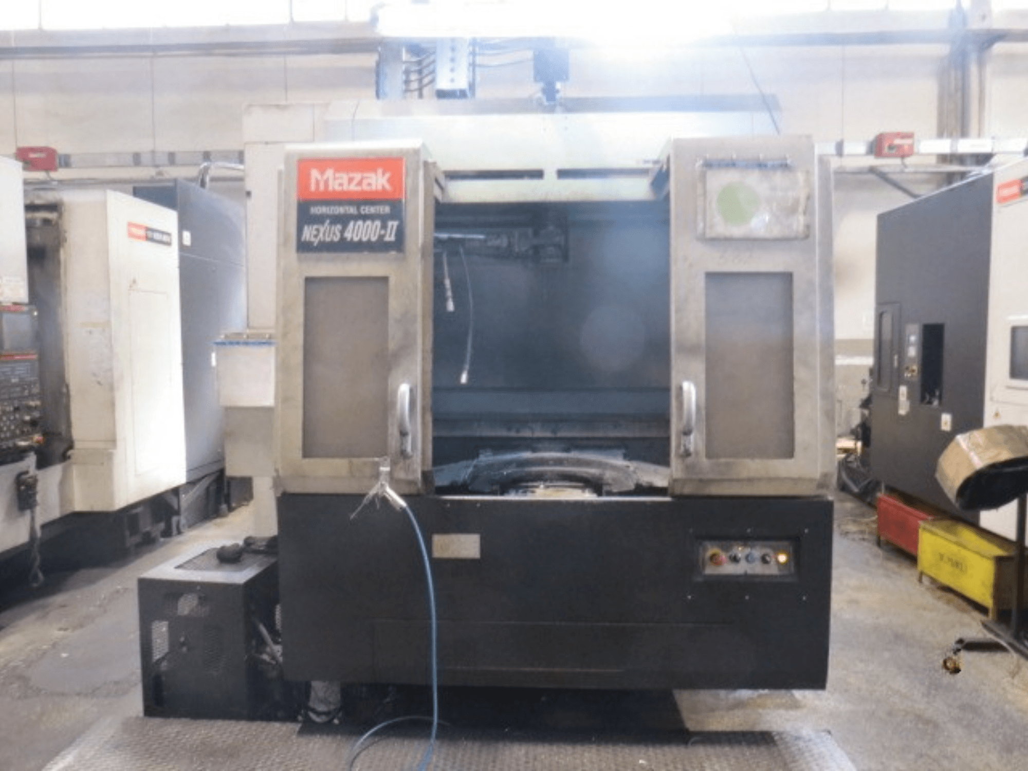 Горизонтальний обробний центр Mazak NEXUS 4000 II, вид спереду, на якому видно панель керування, систему подачі охолоджувальної рідини та відкриту робочу зону.