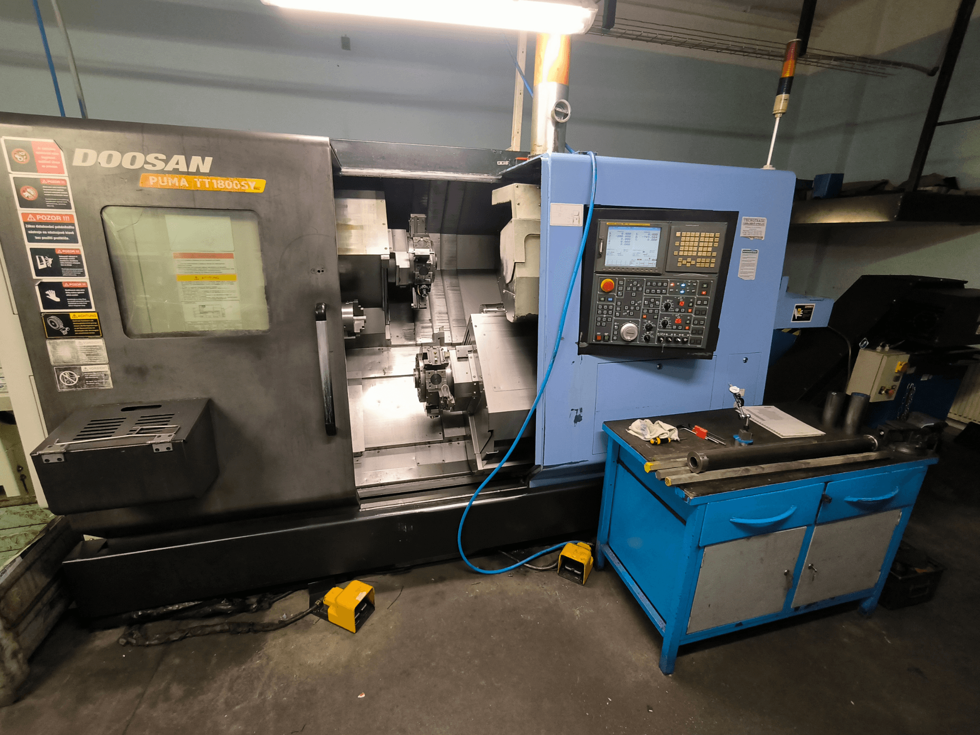Токарний верстат з ЧПУ Doosan Puma TT1800SY, вид спереду, показано панель керування, робочу зону з інструментами та компонентами верстата.