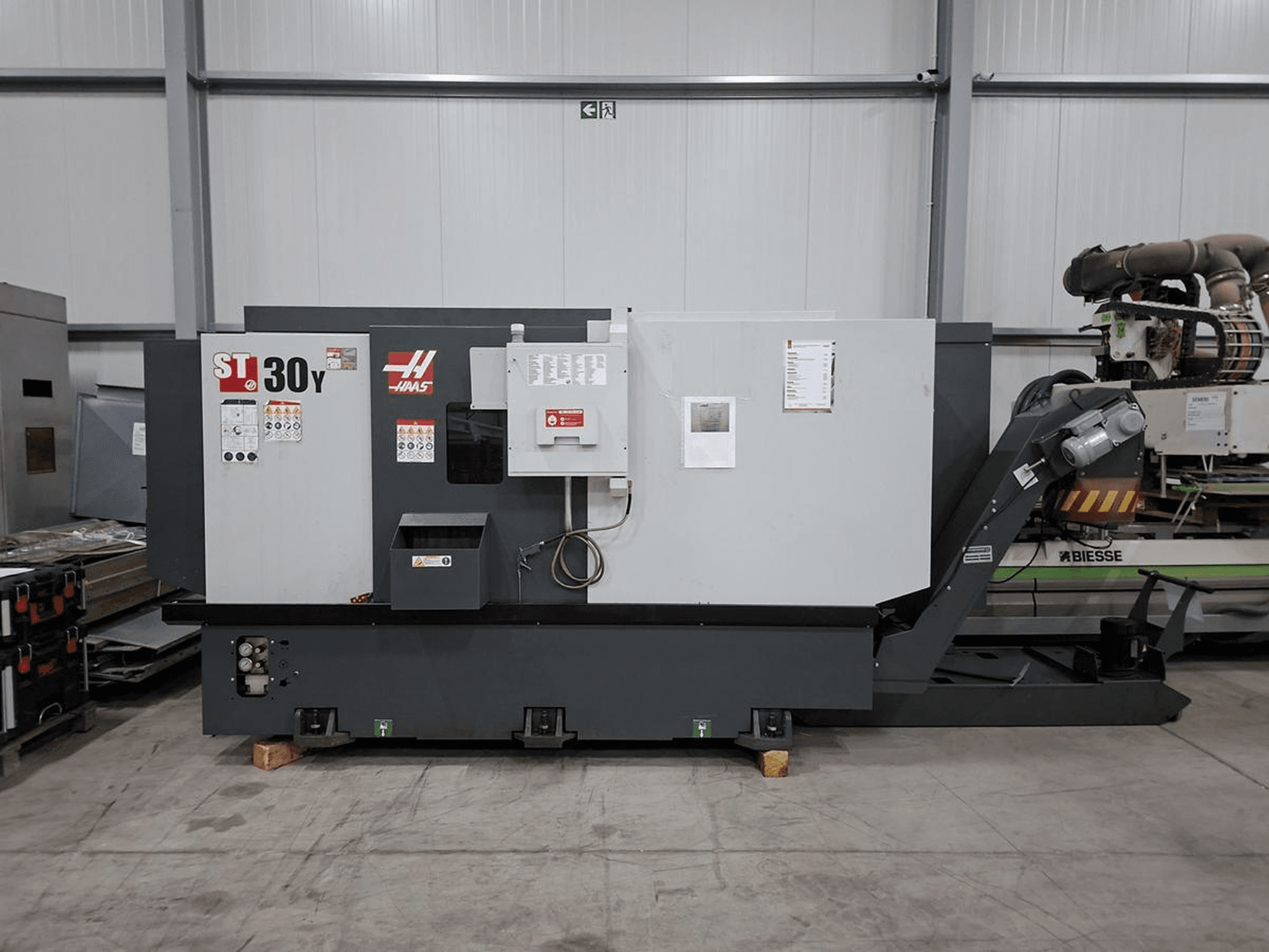 Горизонтальний токарний верстат Haas ST-30Y у боковому ракурсі: на фото видно органи управління, маркування та міцну конструкцію у просторій майстерні.