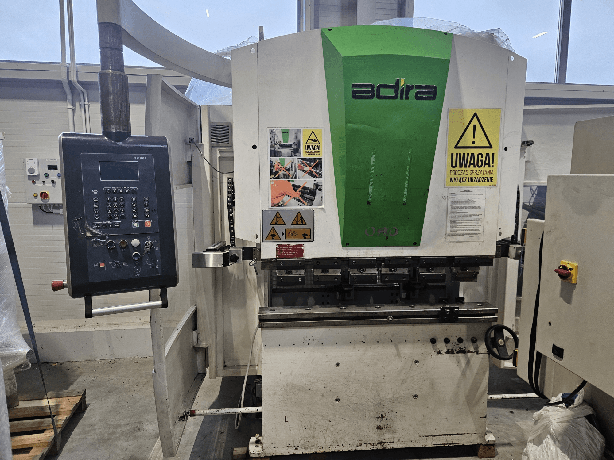 Вид на машину Adira OHD спереду, з панеллю керування, попередженнями про безпеку та кнопками керування.