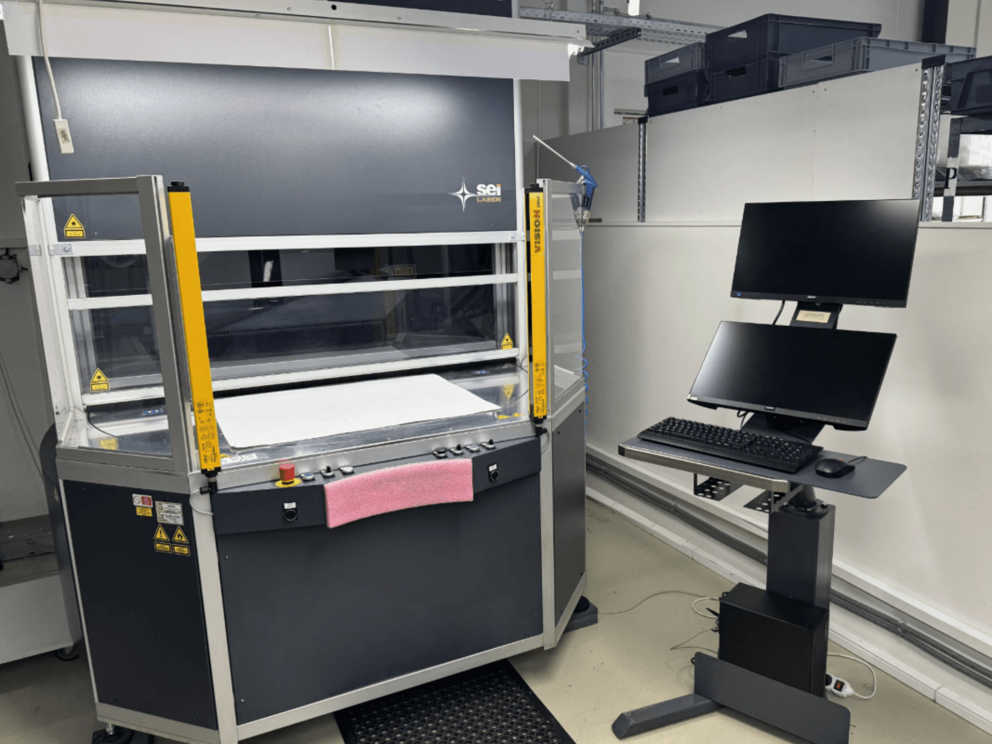 Лазерний верстат для різання CO2 SEI Laser INFINITY 5070 V300 у фронтальному ракурсі, з панеллю керування та підключеною моніторною станцією.
