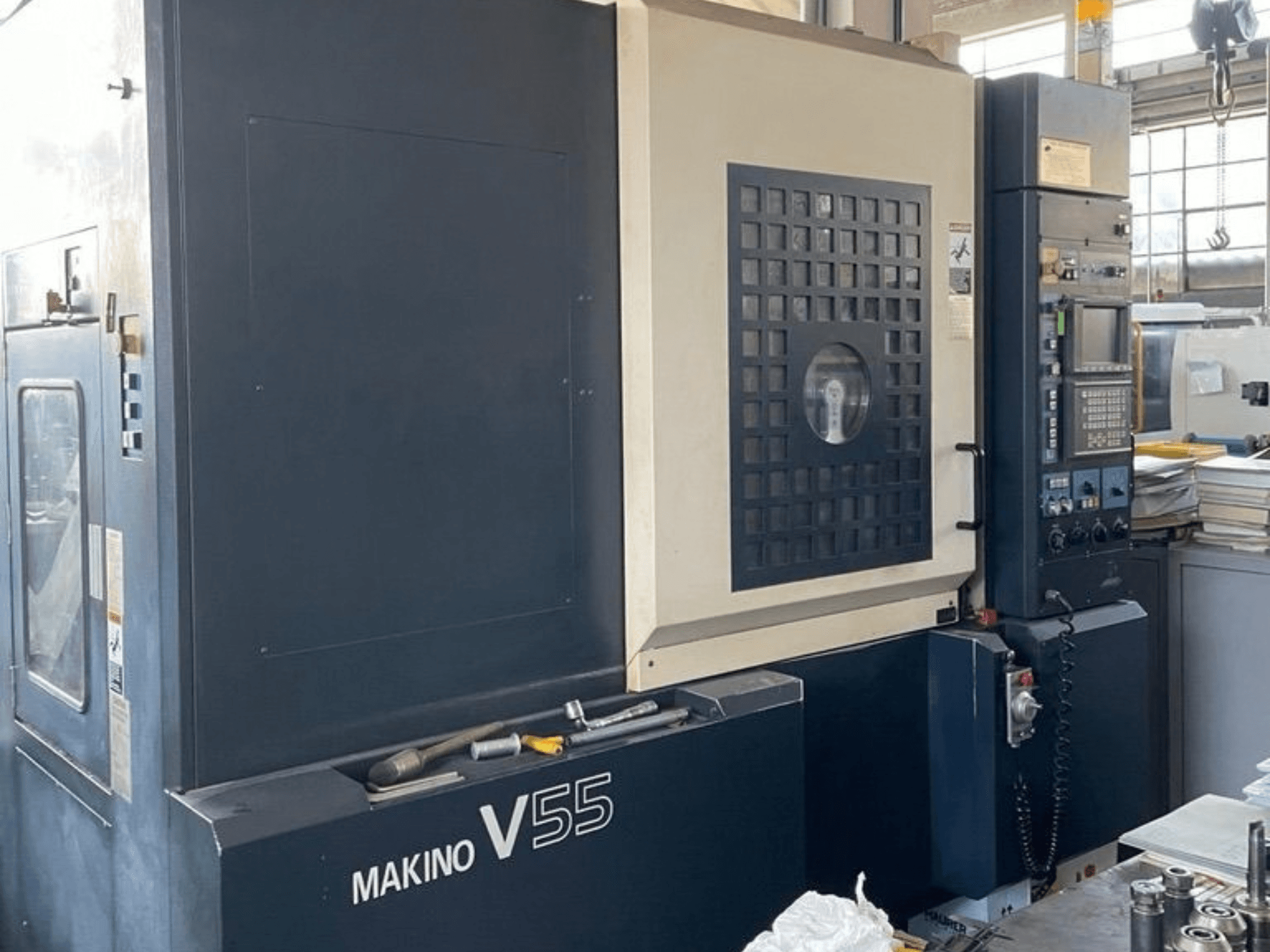 Вертикальний обробний центр Makino V55-A15, вид спереду, на якому видно панель управління, міцну конструкцію та облаштування робочої зони.