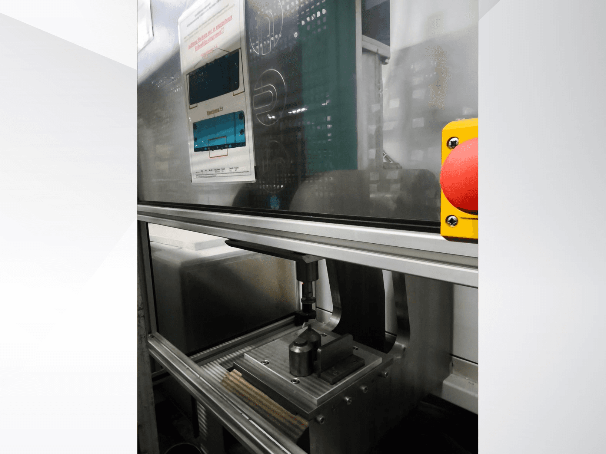 Вид спереду на верстат EMS Automation Buchsenpresse, що демонструє притискний механізм і запобіжну кнопку.