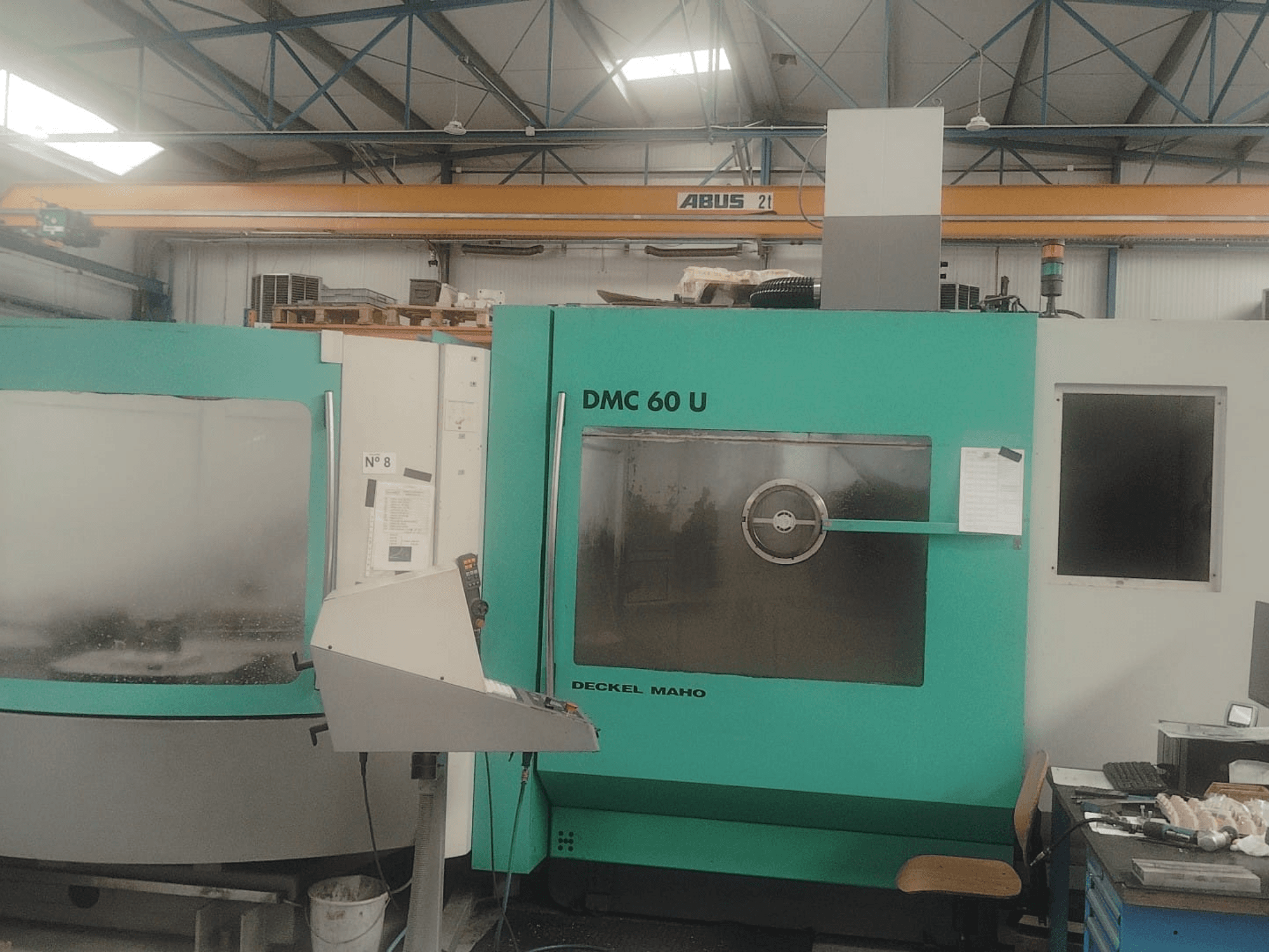 Вид спереду фрезерно-токарного центру DECKEL MAHO DMC 60 U з панеллю керування та великим скляним оглядовим вікном.