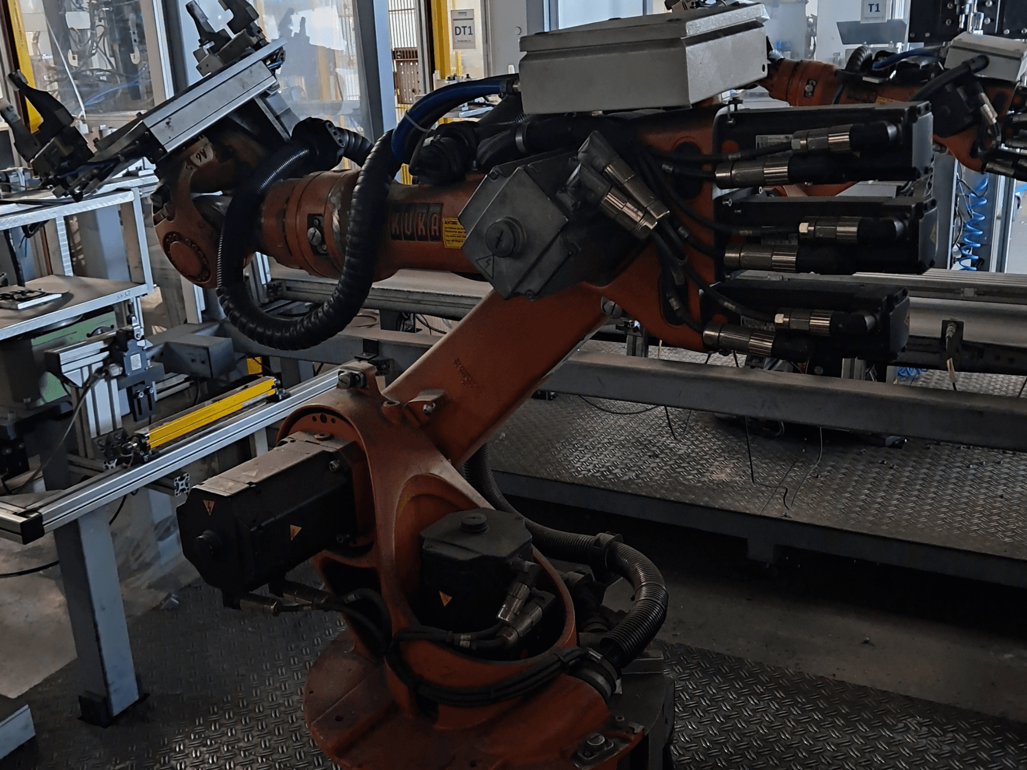 Роботизована рука KUKA KR 16-2 з контролером KRC 4, вид збоку, на якому видно шарнірні з’єднання та гідравлічні підключення.