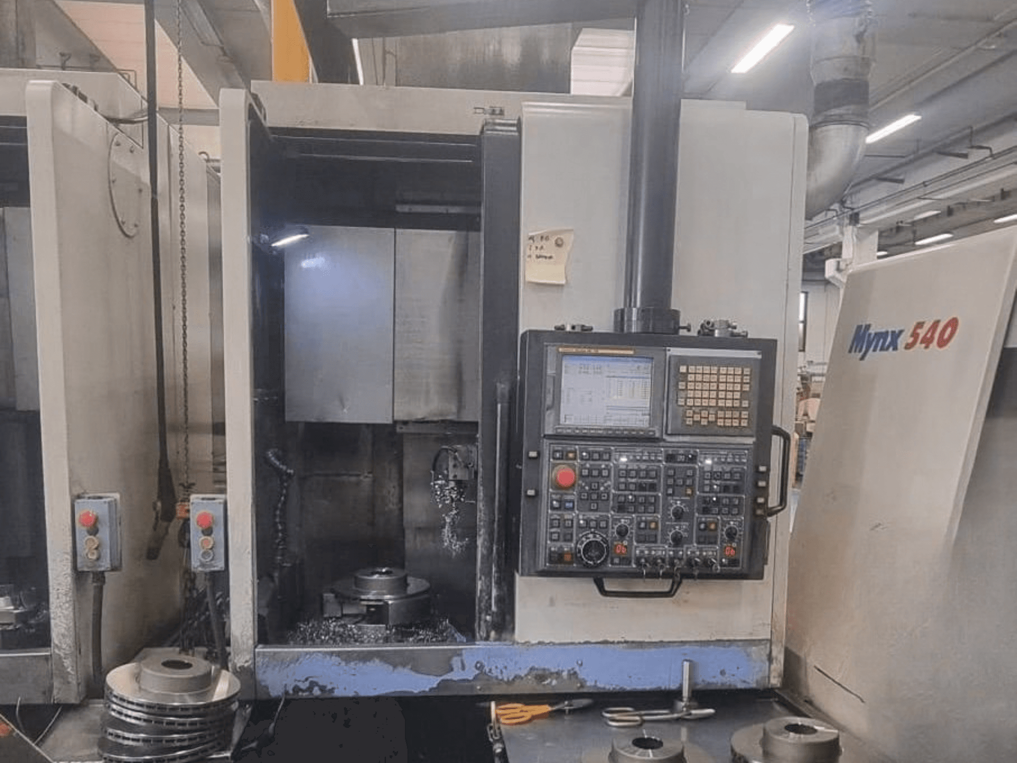Вигляд спереду вертикального токарного верстата DOOSAN PUMA V400-2SP, на якому видно панель керування та заготовку, встановлену всередині верстата.