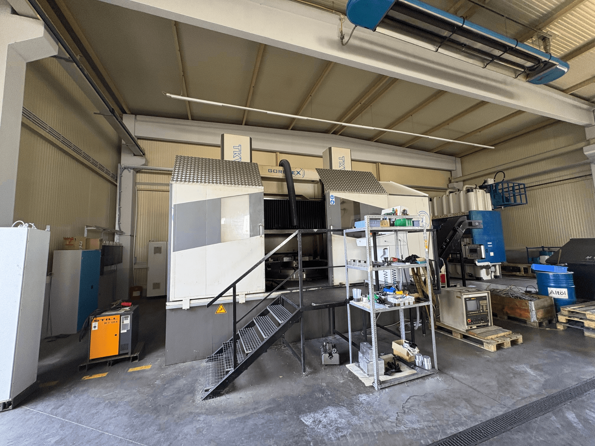 Промислова установка для обробки на верстаті GORAT X, вид збоку; включає в себе інструменти, панель управління та обладнання на полицях.