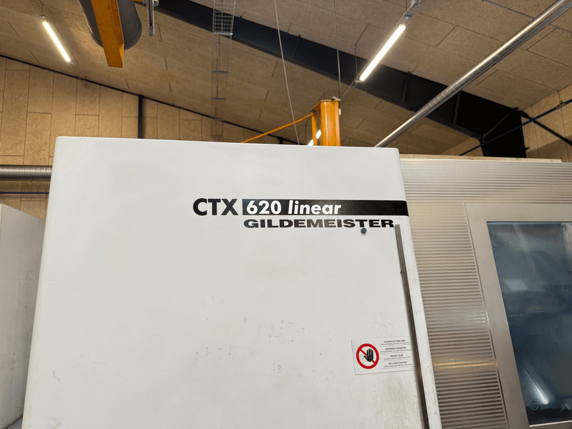 CTX 620 Linear Gildemeister - вид збоку, з білим зовнішнім виглядом і попереджувальними написами про безпеку.