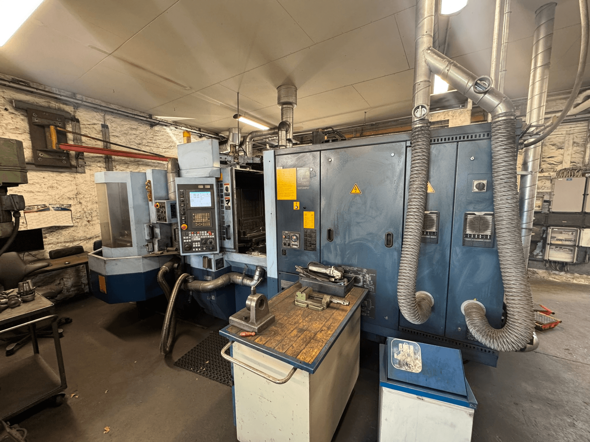 Горизонтальний обробний центр Matsuura H.PLUS-300 у цеху, вид спереду, на якому видно панель управління та робочий стіл.