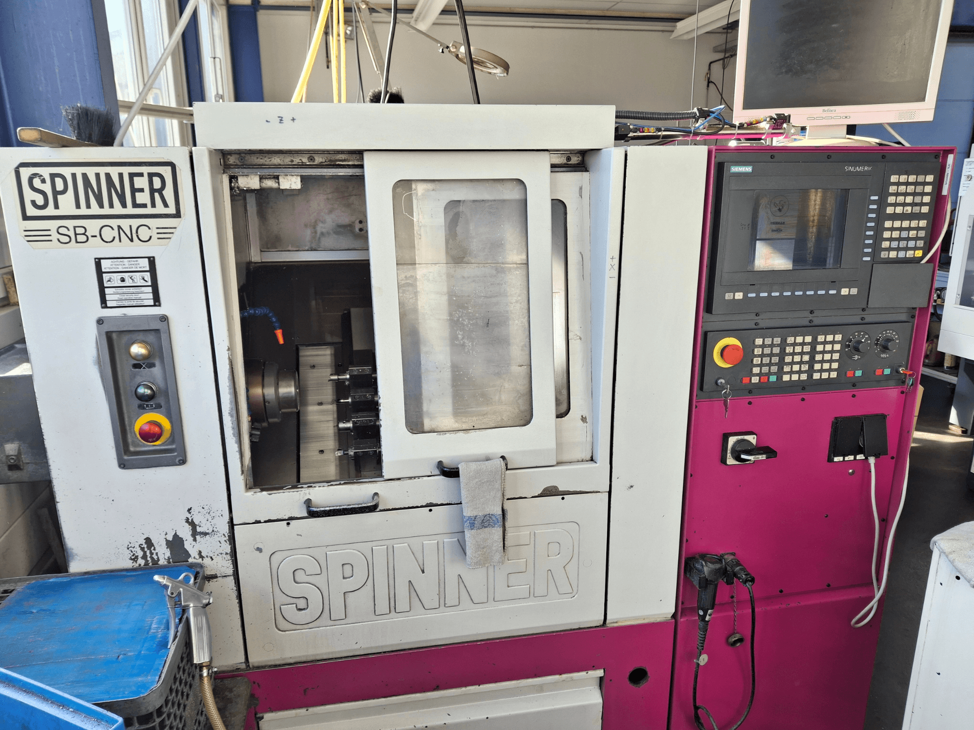 Горизонтальний токарний верстат SPINNER SB-CNC, вид спереду з панеллю керування, тримачем інструменту та робочими індикаторами.