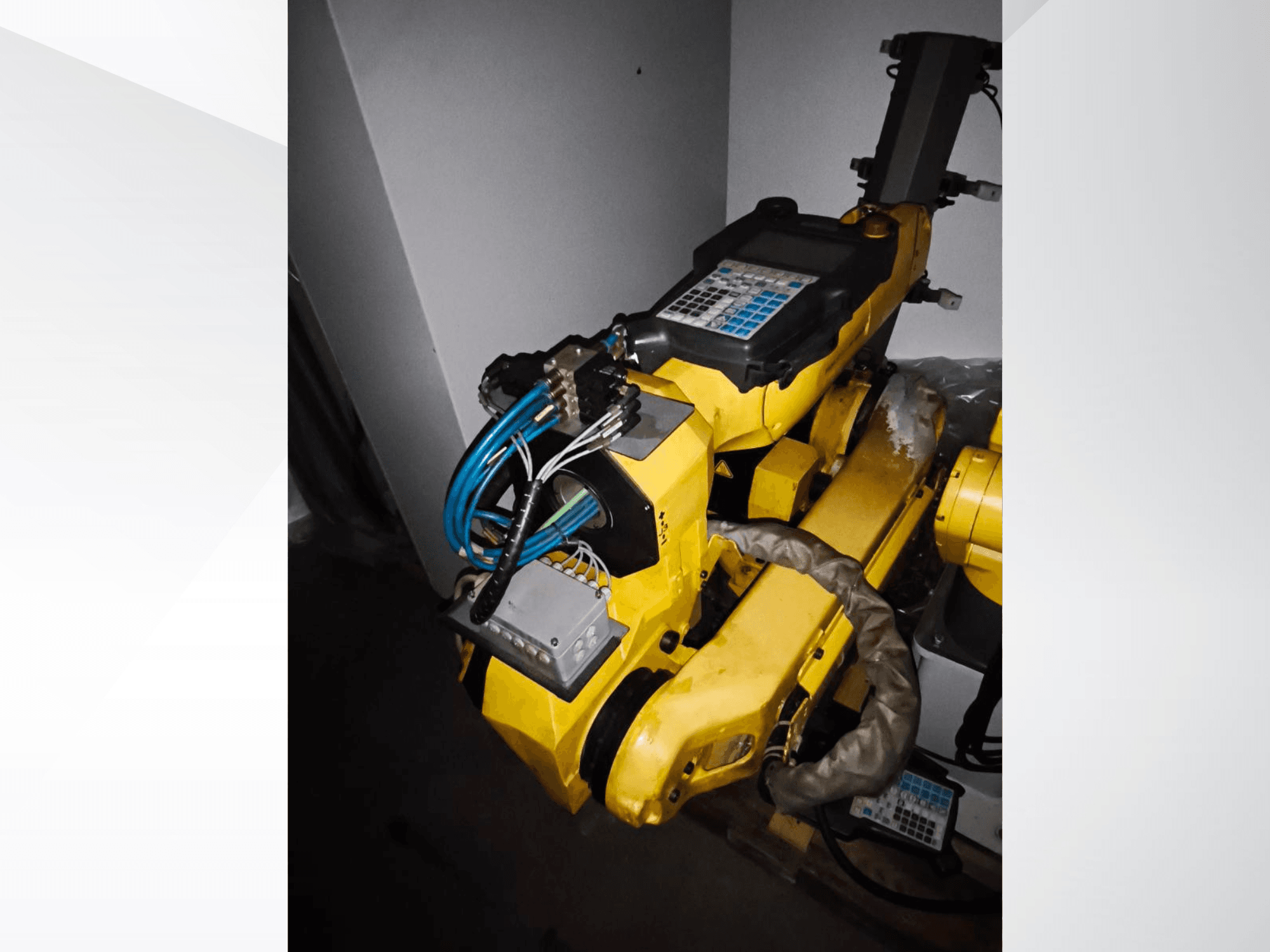 Робот-маніпулятор FANUC M-20iA у вигляді збоку, з жовтим корпусом, панеллю керування та підключеною проводкою.
