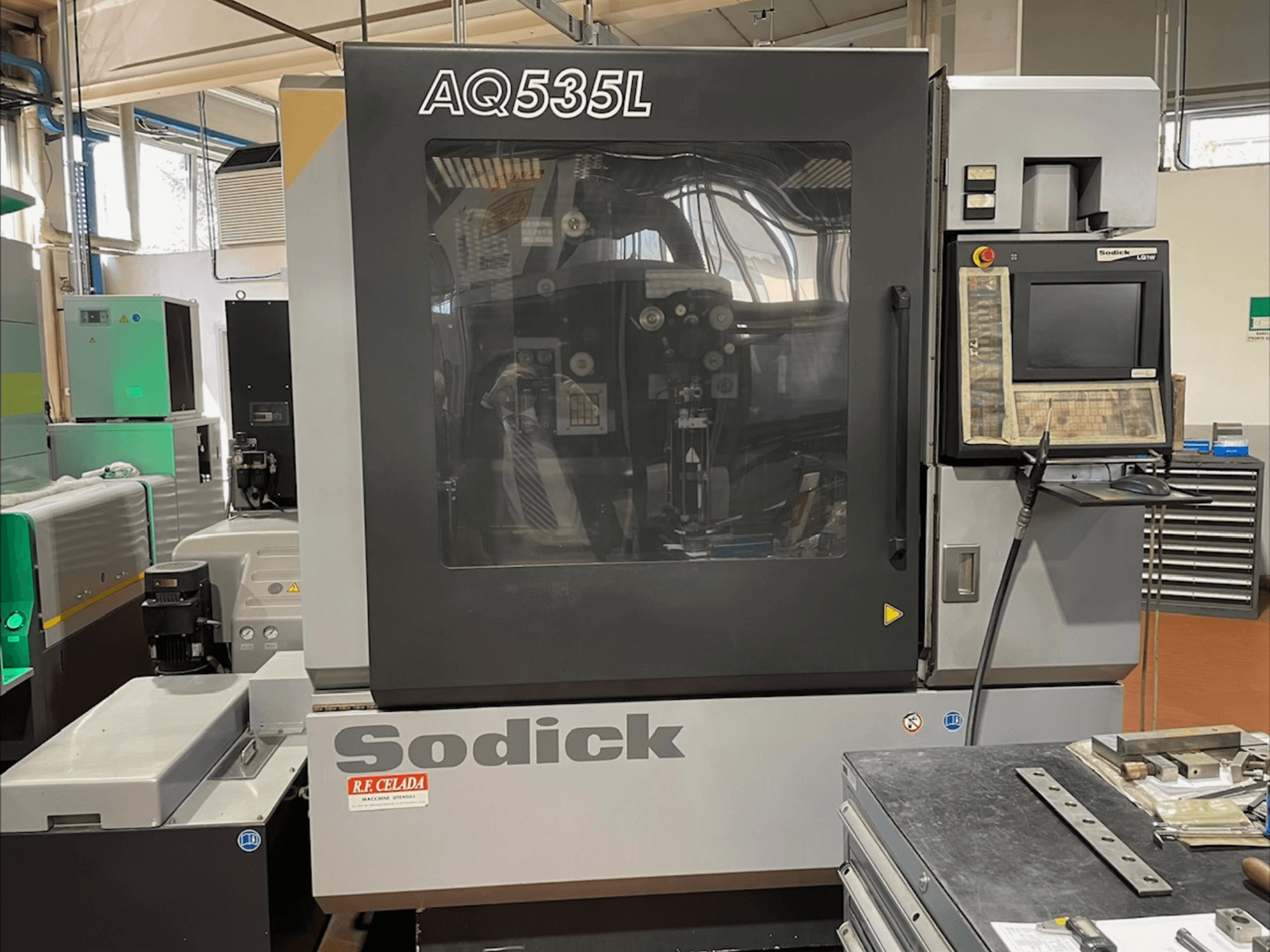 Електроерозійний верстат Sodick AQ535L вид спереду, з панеллю керування та прозорим захисним кожухом.