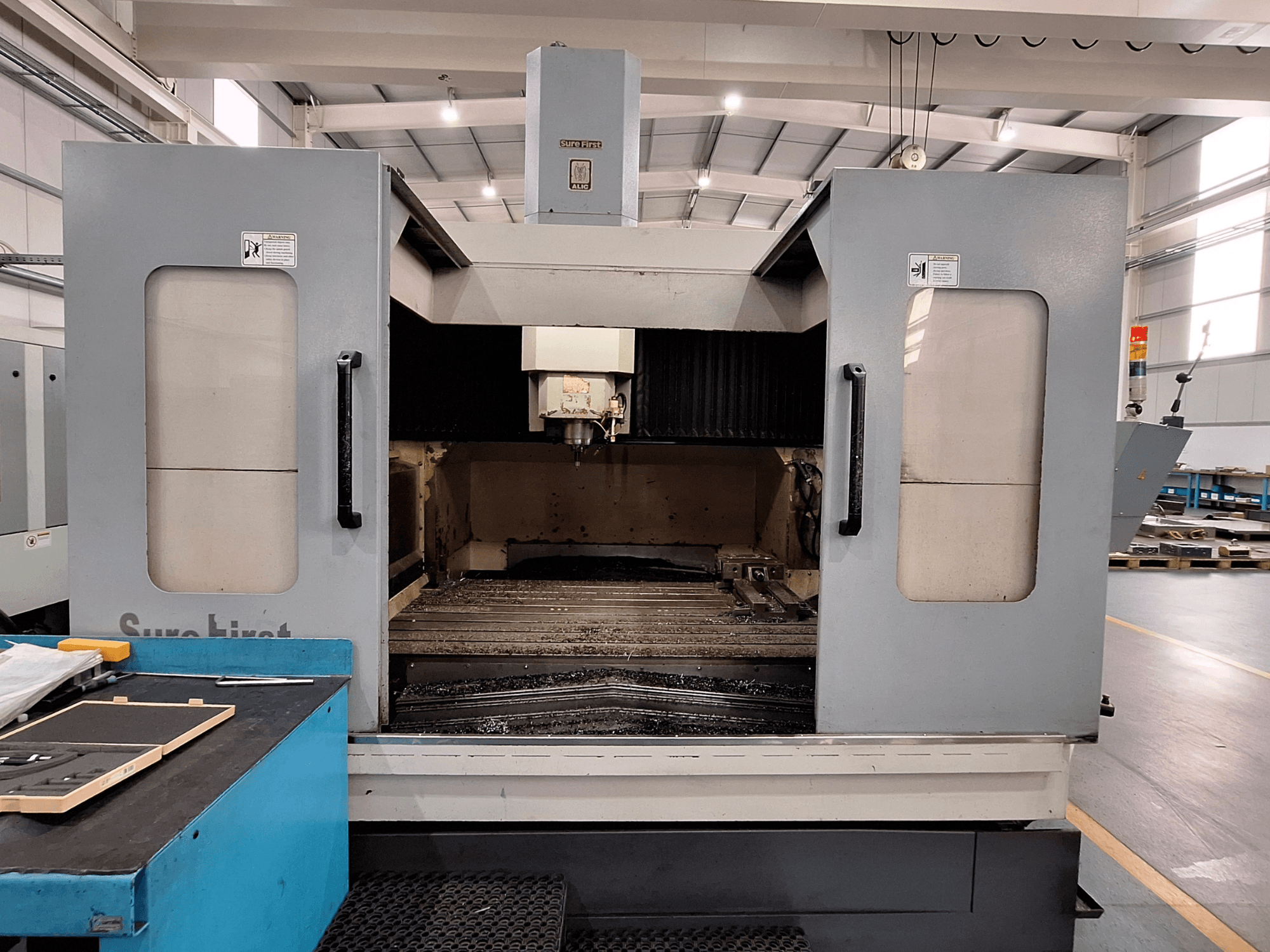 Вертикальний обробний центр Sure First QM-1836, вид спереду з головкою інструменту та порожньою робочою зоною, сучасна промислова установка.