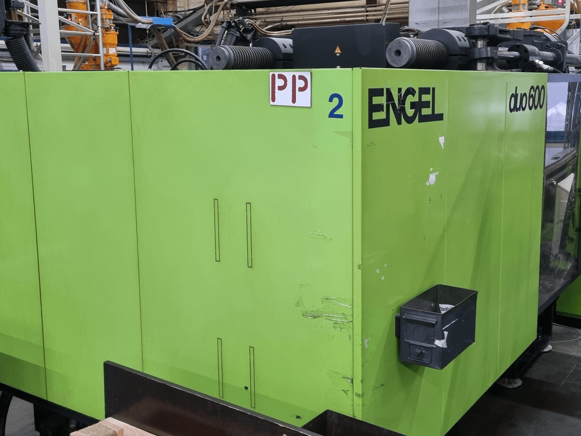Гідравлічна термопластавтомат Engel duo 600, зелений корпус, вид спереду, з позначеними деталями та ящиком для зберігання матеріалів.