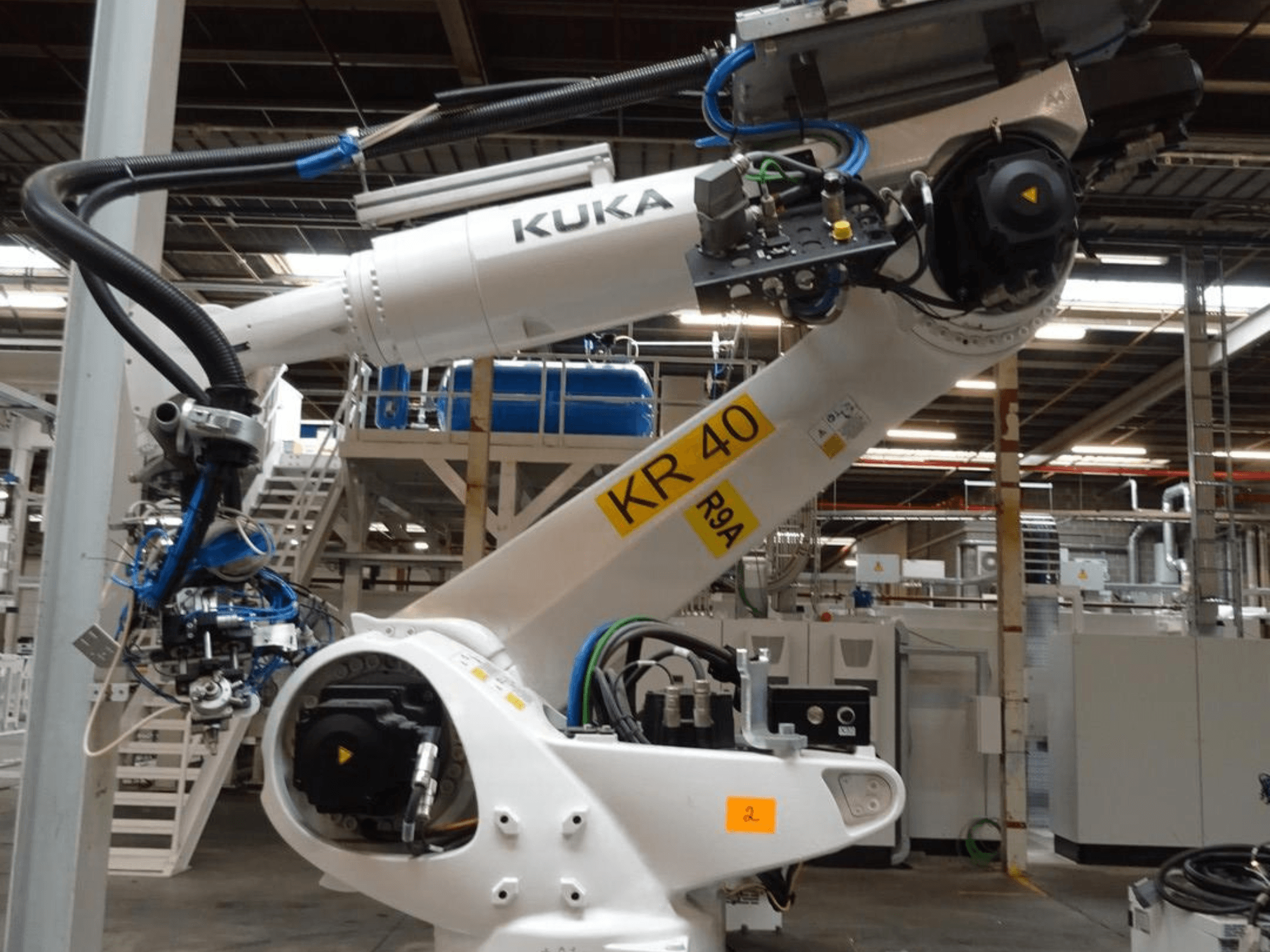 Роботизований маніпулятор KUKA KR 120 R3100-2 у вигляді збоку, демонструє панель управління та механічні компоненти, встановлені в промисловому середовищі.