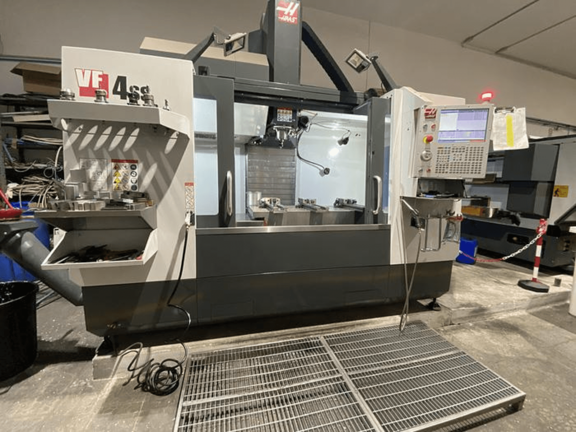 Фрезерний верстат з ЧПК Haas VF-4SS, вид спереду, зі сховищем для інструментів, панеллю керування та видимою робочою зоною в умовах майстерні.
