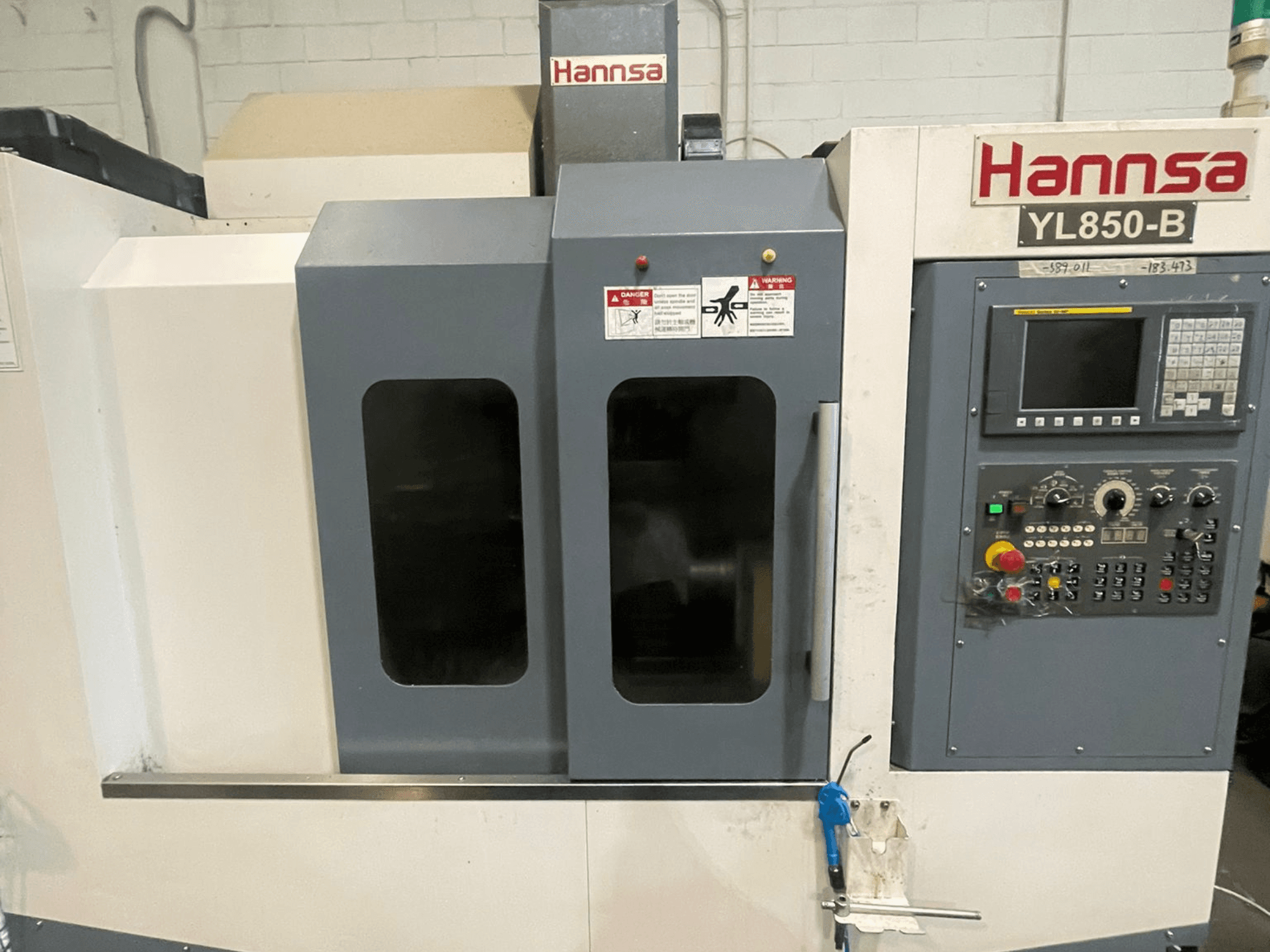 Вертикальний обробний центр HANNSA YL850-B, вид спереду, з панеллю керування, кнопками керування та двома оглядовими вікнами.