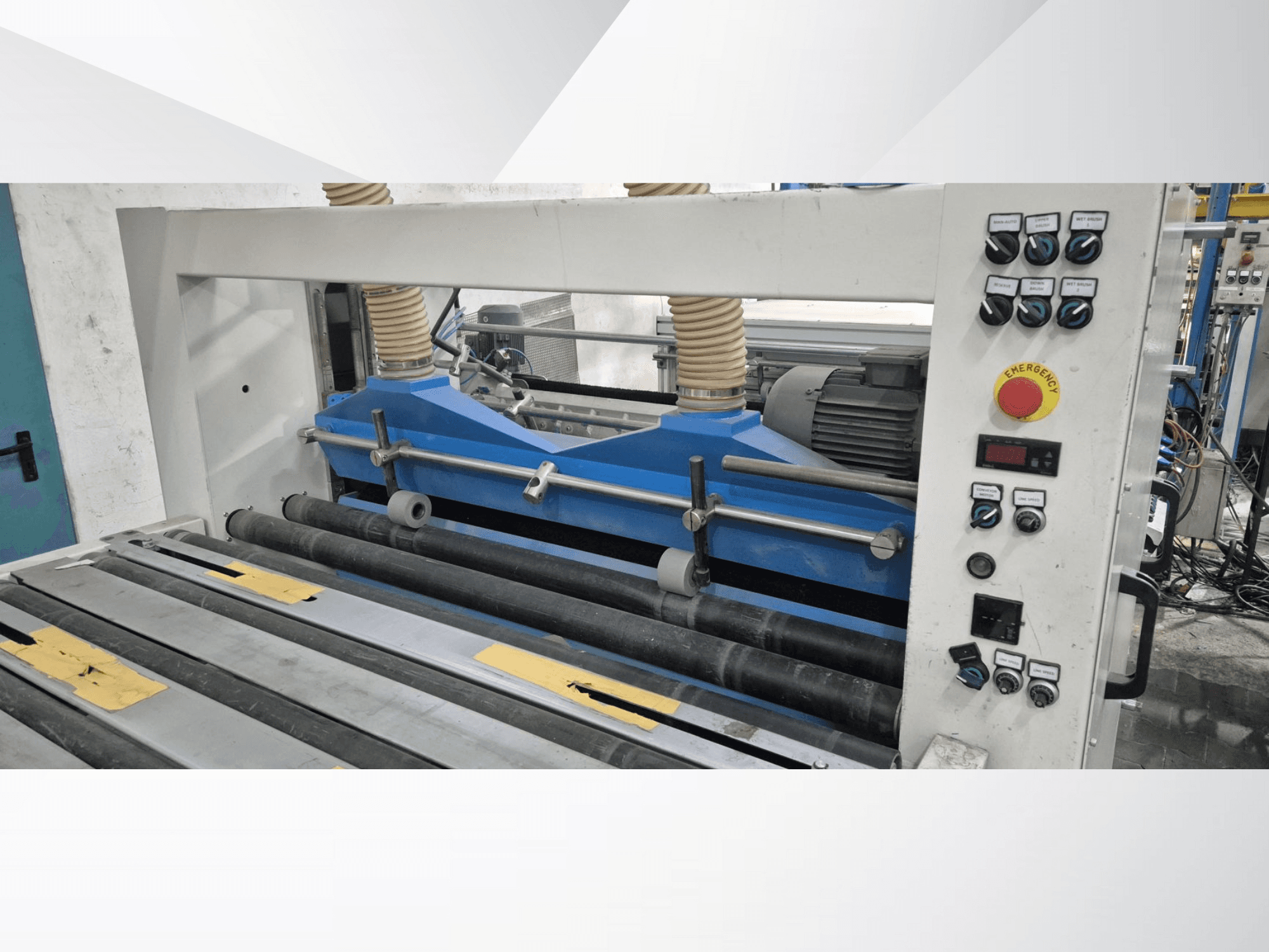 Промислова вальцювальна машина з синіми компонентами, вид спереду, з панеллю керування та кнопкою аварійної зупинки.