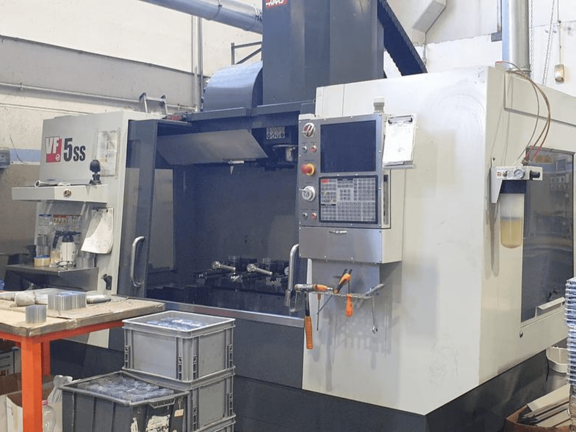 Вертикальний обробний центр HAAS VF-5SS - вид спереду, з панеллю керування, робочою зоною та накопичувальними бункерами.