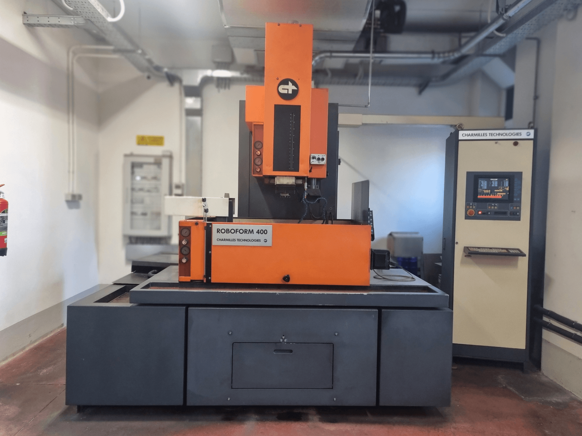 Машина Roboforn 400 від Charmilles Technologies, вид спереду, з оранжево-сірим дизайном, видно цифрову панель управління.