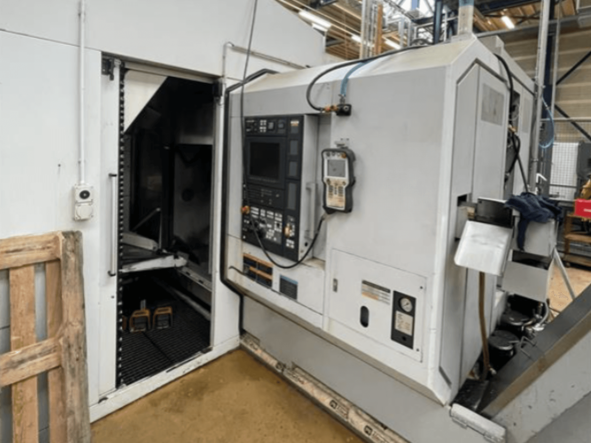 Горизонтальний токарний верстат DMG Mori Seiki NZ2000T3Y2, вид збоку з панеллю керування та внутрішньою частиною верстата.