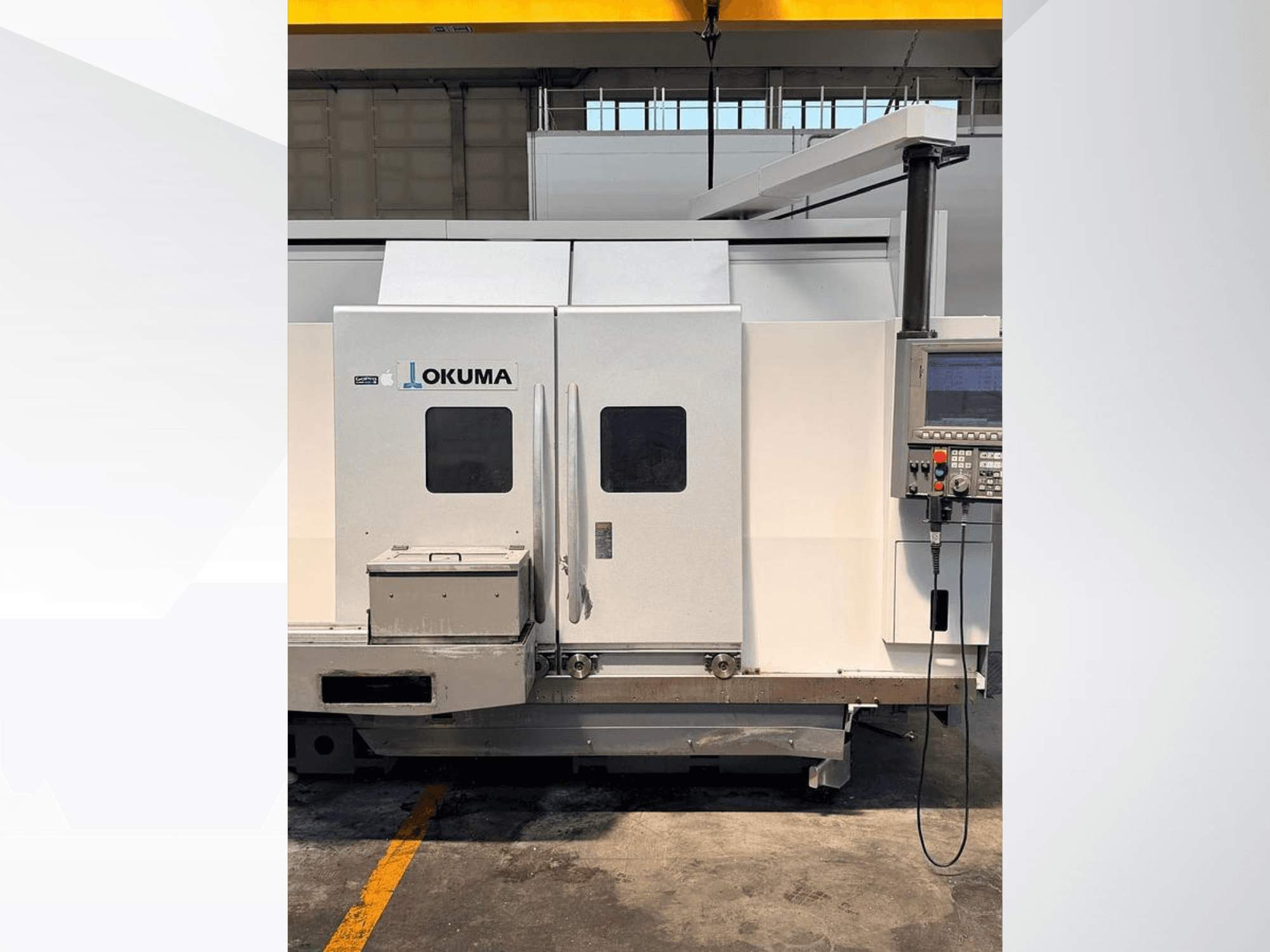 Горизонтальний токарний верстат Okuma LB 3000 EX MYW 800, вид збоку, на якому видно панель управління та дверцята доступу.
