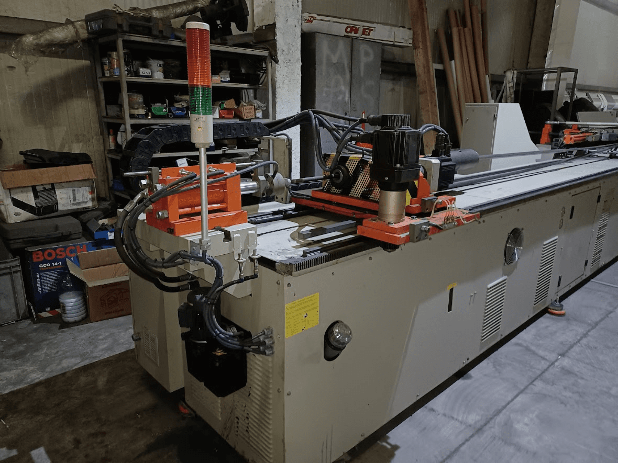 Машина для гнуття штампів CANSA CNC 51 R1, вид збоку, на якому видно панель управління, двигун та сигнальні лампочки в умовах цеху.