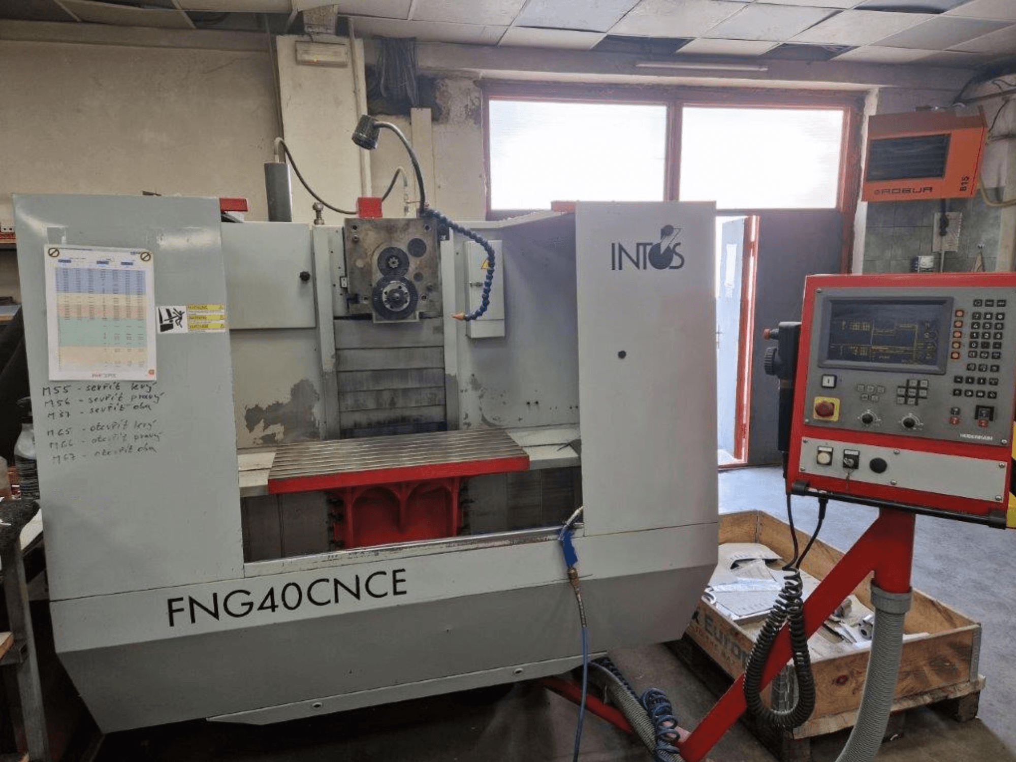 Верстат INTOS FNG40CNC, вид спереду, має панель керування, робочі частини та металевий робочий стіл. Ідеально підходить для механічної обробки.