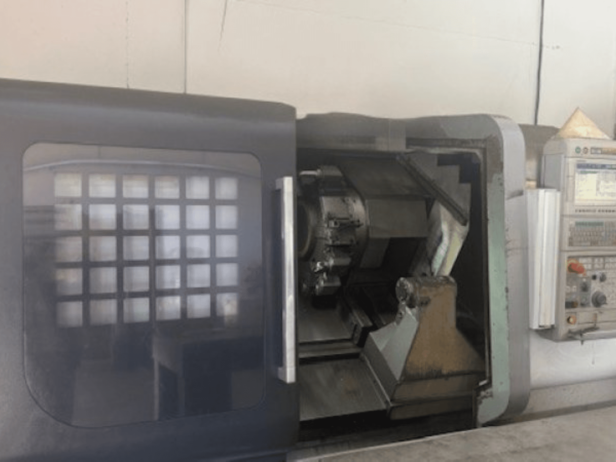 Горизонтальний токарний верстат MORI SEIKI NLX 2500M, вид спереду: тримач інструменту, панель керування та внутрішній механізм.