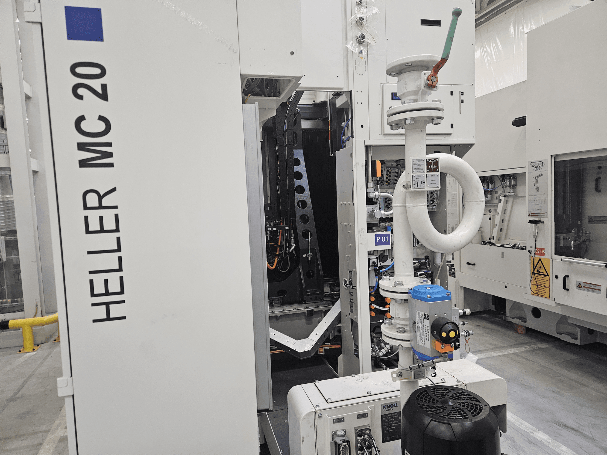 Верстат Heller MC 20 у заводських умовах, демонструє панель управління та механічні компоненти збоку.