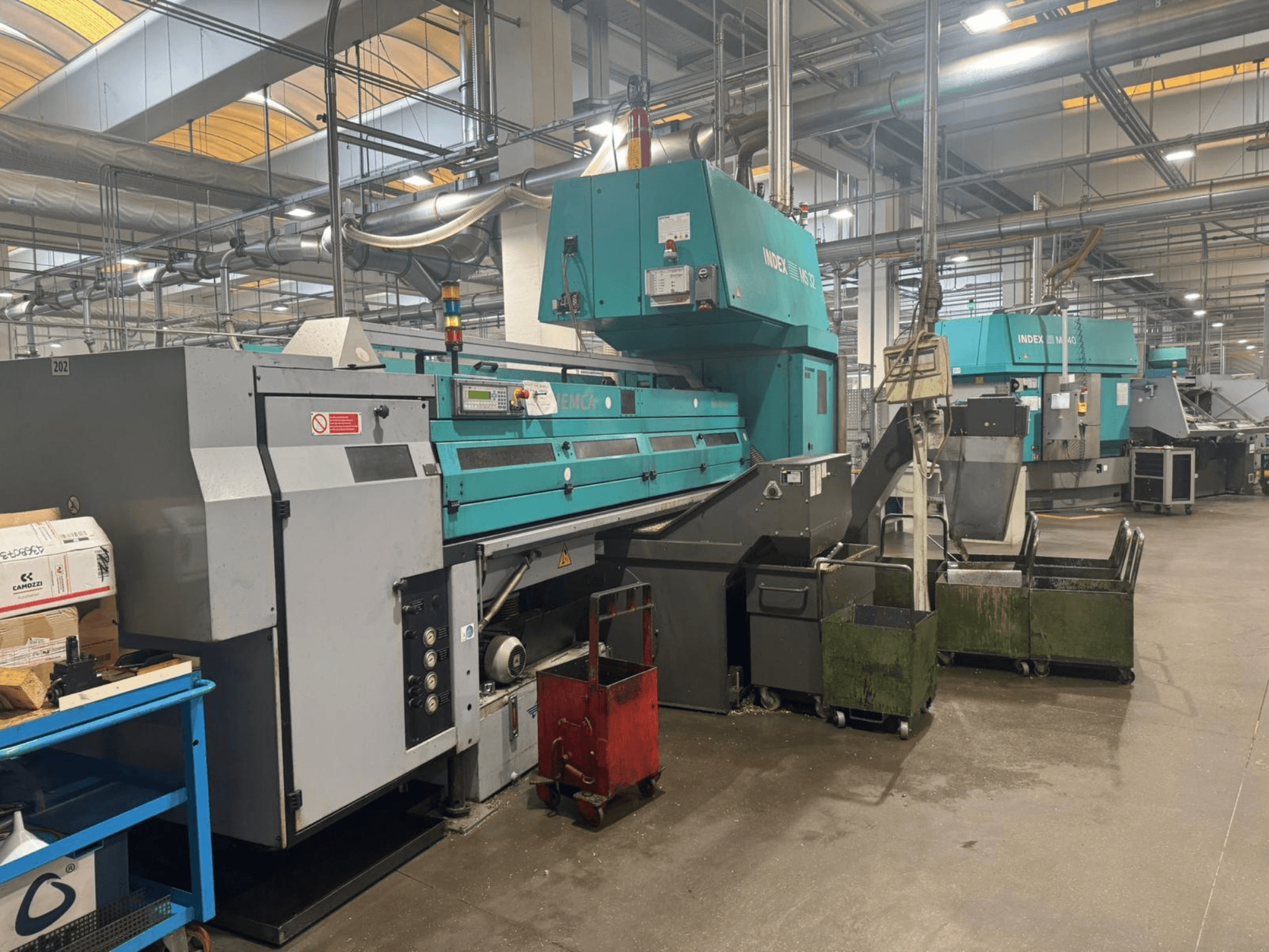 Багатошпиндельний токарний верстат INDEX MS32C, вид спереду з елементами керування та робочою зоною в умовах майстерні.