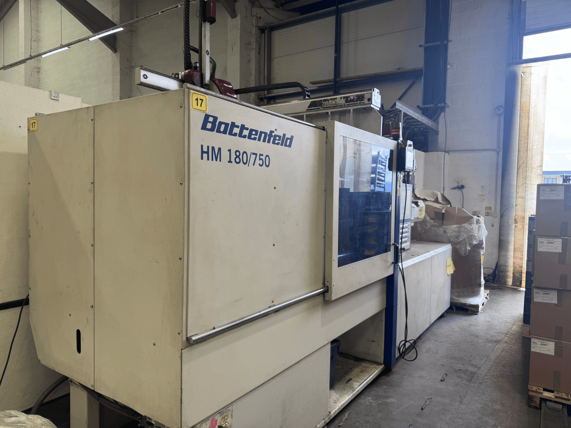 Гідравлічний термопластавтомат Battenfeld HM150750 спереду, демонструючи панель керування та навколишнє обладнання.