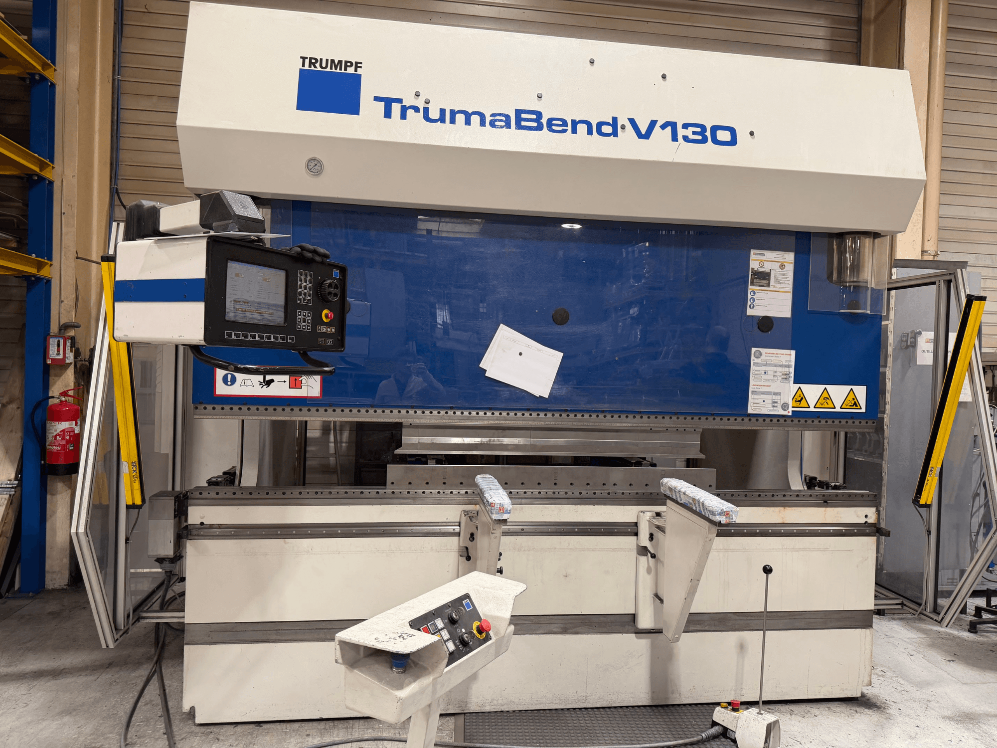 Гнучкий прес TRUMPF TrumaBend V130 у заводській комплектації, з панеллю керування та засобами безпеки, вид спереду.