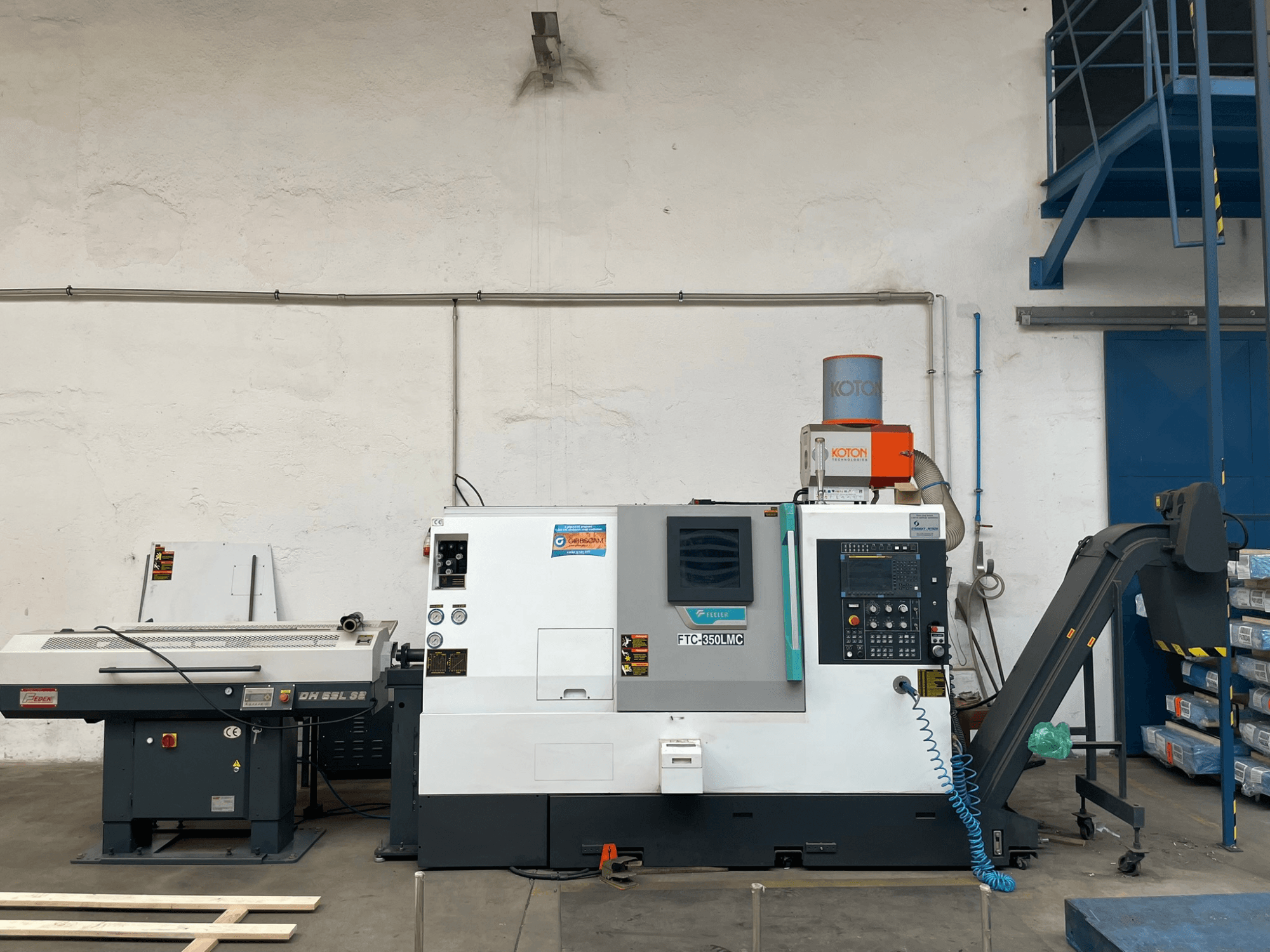 Горизонтальний токарний верстат Feeler FTC 350 LMC в майстерні, демонструє панель керування та лінії подачі інструменту. Вид збоку.