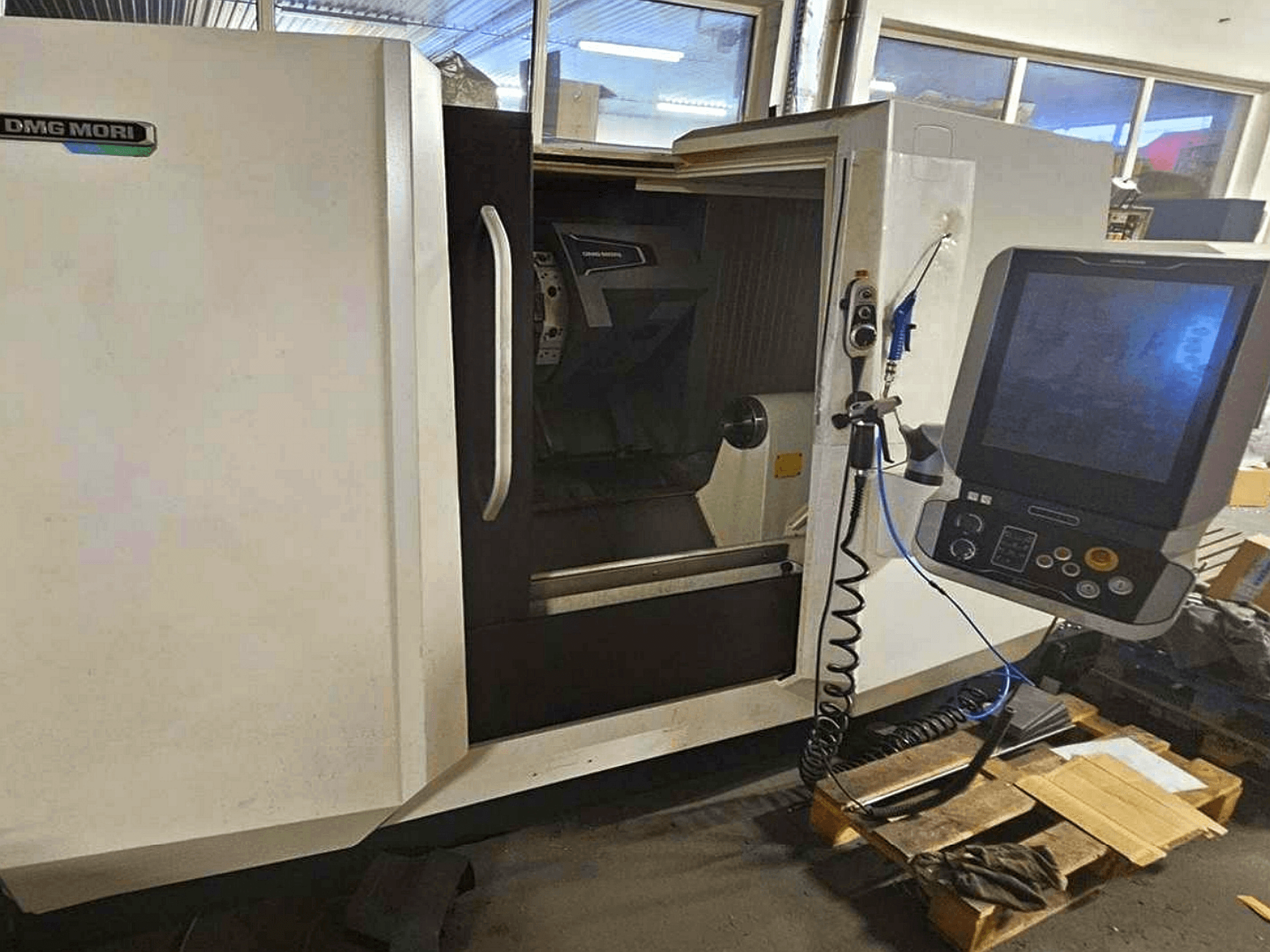 Горизонтальний токарний верстат DMG MORI CLX 450 V4, вид спереду з панеллю керування, що демонструє робочий простір і дизайн корпусу.