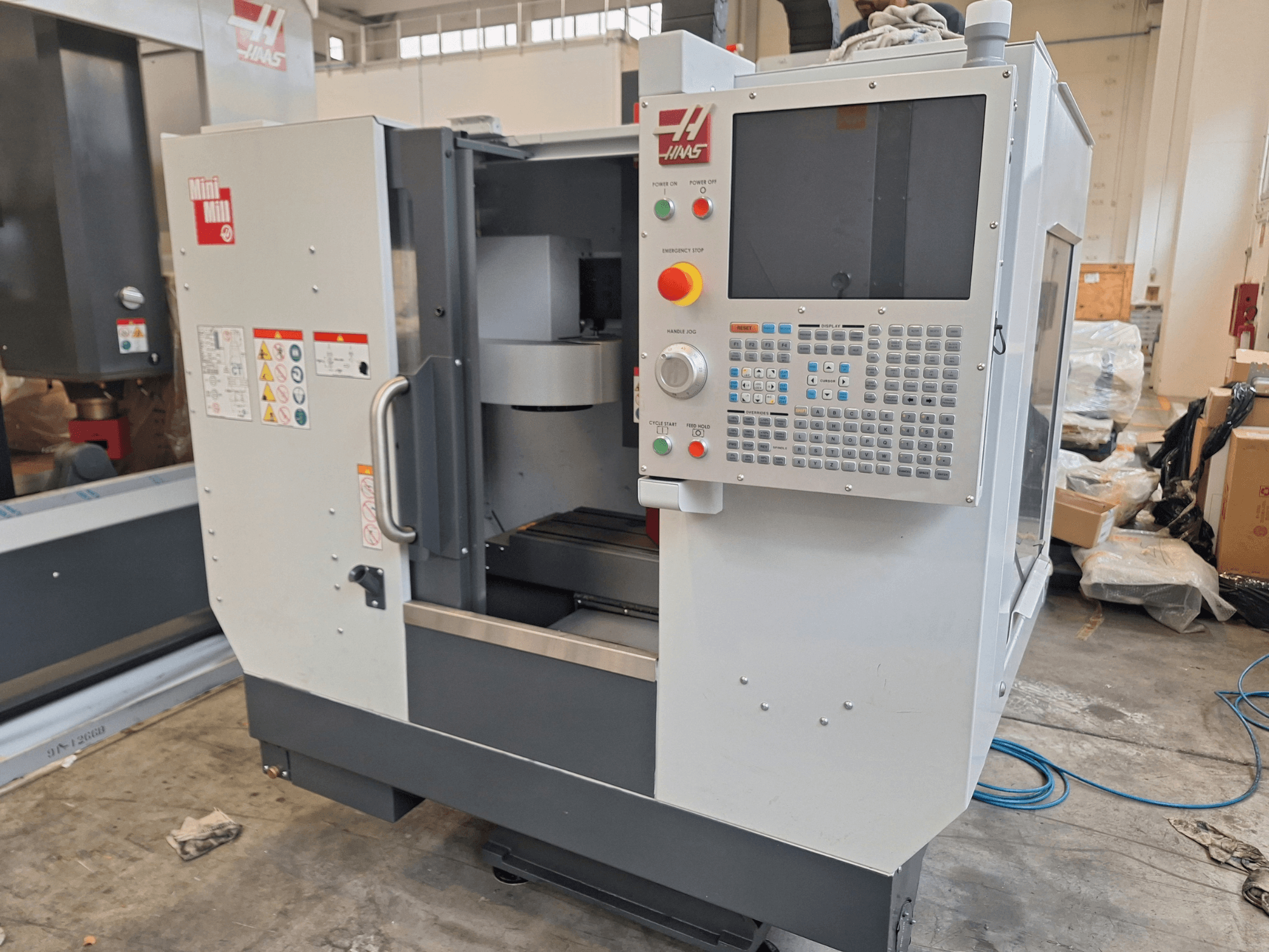 Вертикальний обробний центр HAAS Mini Mill у вигляді спереду, на якому видно панель управління з кнопками та дисплеєм.