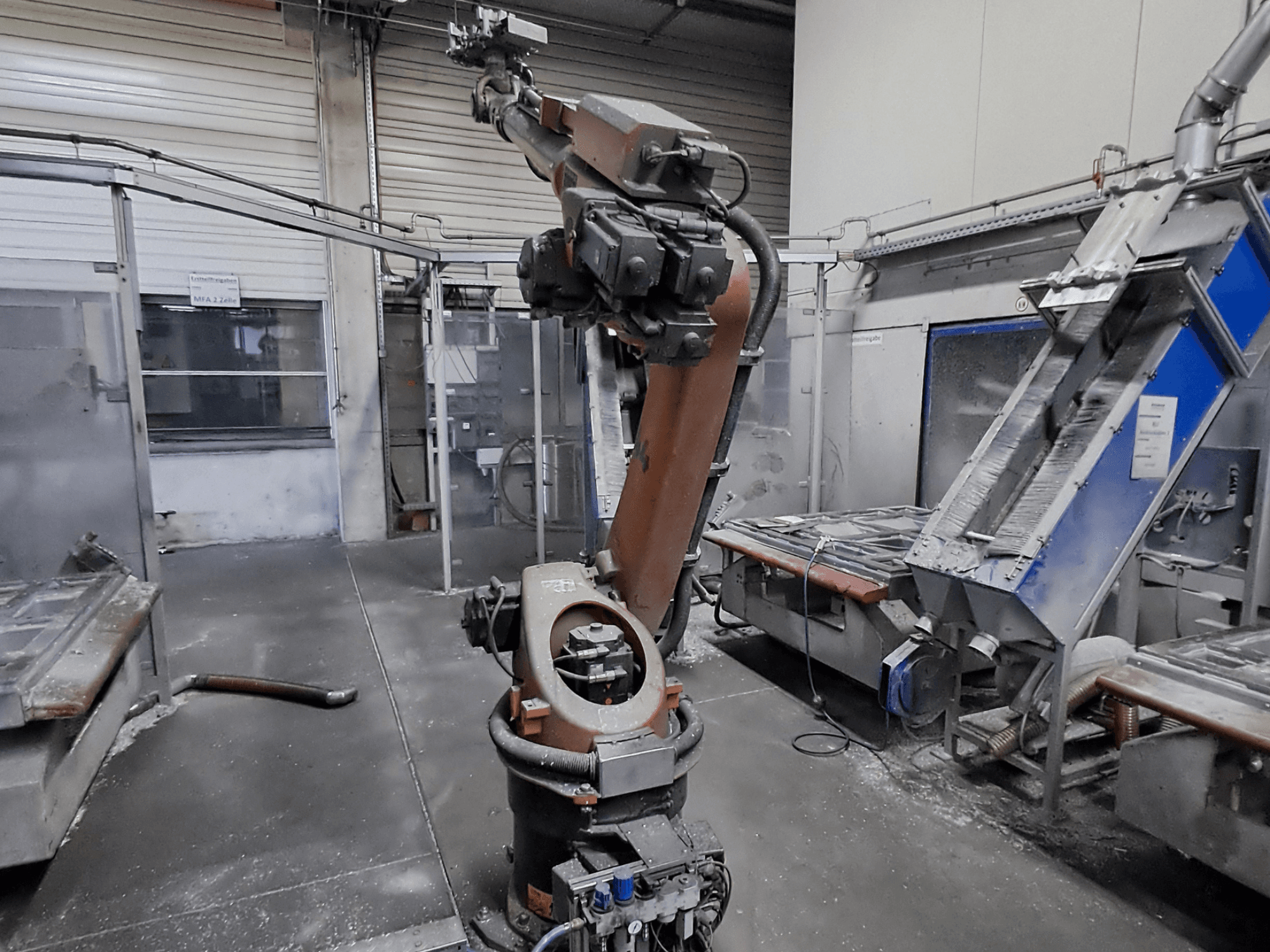 Роботизована рука KUKA KR 30L16-2 у цехових умовах, вид спереду, на задньому плані видно пил та обладнання.
