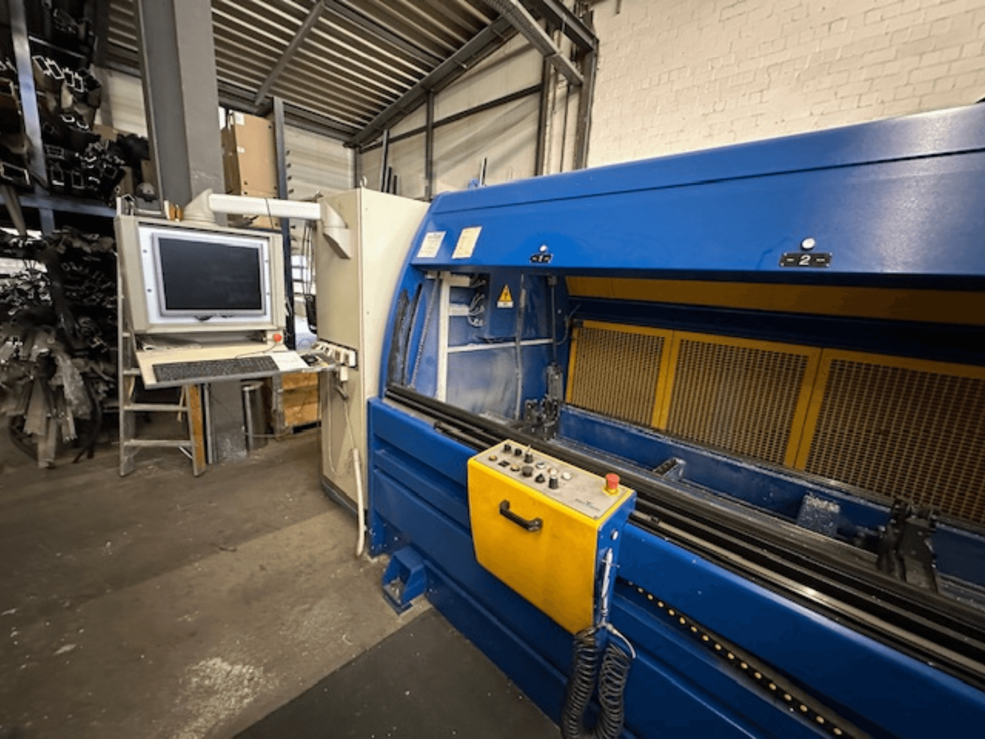 Вид спереду на універсальний обробний центр SCHÜCO Profilbearbeitungscenter 299 650 з елементами керування та комп'ютерною робочою станцією.