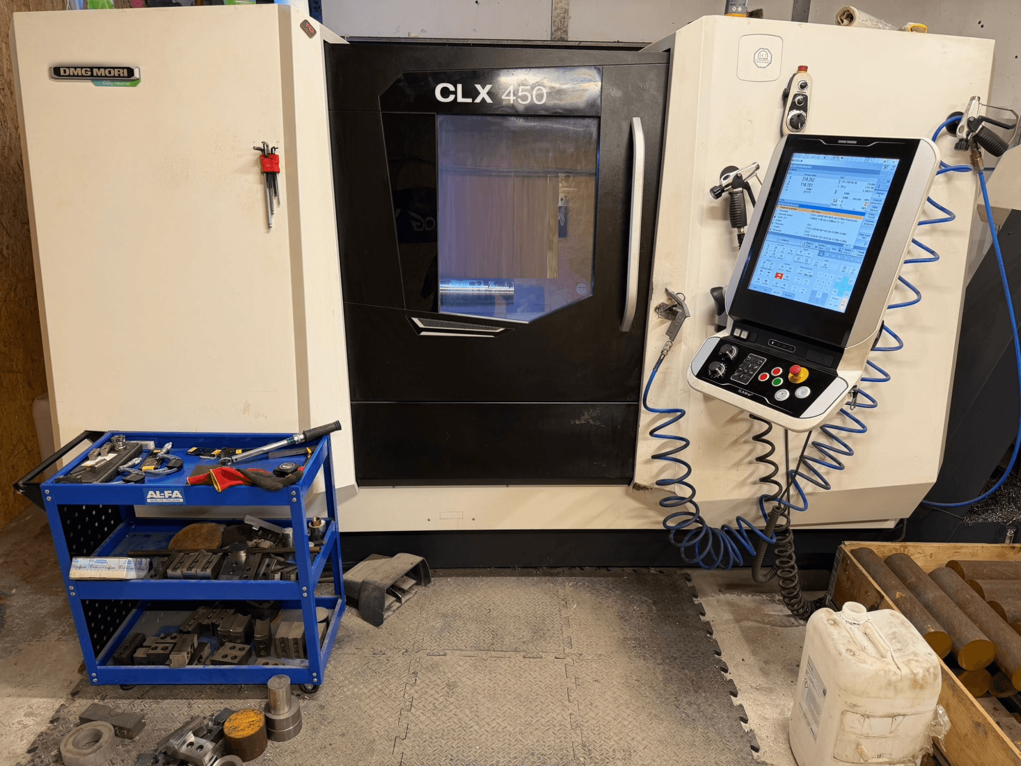 Горизонтальний токарний верстат DMG MORI CLX 450 V3 вид спереду, з панеллю керування та інструментальним візком з обладнанням, що стоїть поруч.
