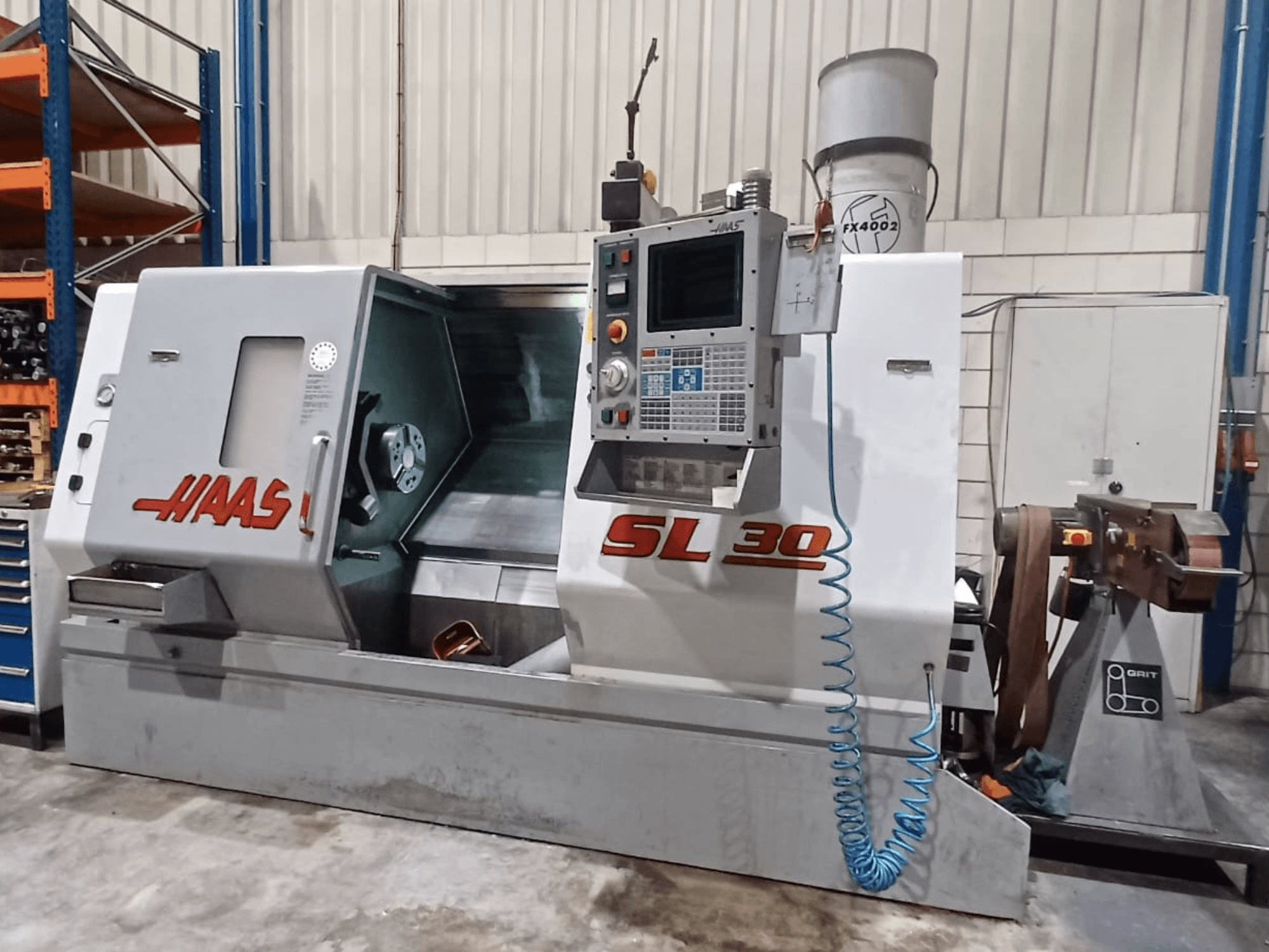 Токарний верстат з ЧПК Haas SL 30 у вигляді збоку, демонструє панель керування, зону обробки та інтегровану систему охолодження для металообробки.