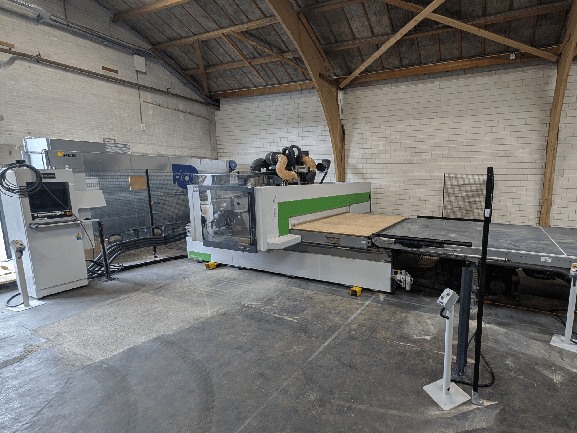 Обробний центр з ЧПК PCK, вид спереду, має велику робочу поверхню, панель керування, систему відсмоктування пилу та міцну конструкцію.