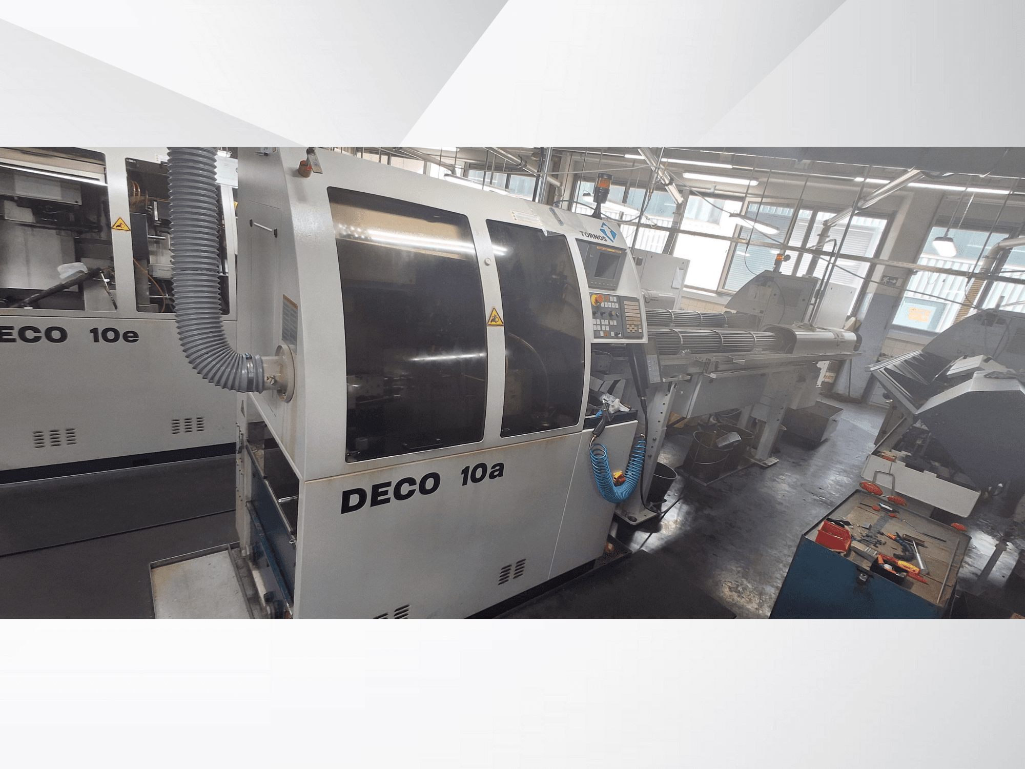 Верстат з ЧПК DECO 10a в майстерні, вид спереду, панель керування та вихлопна система. Відрізняється міцною конструкцією та точними інструментами.