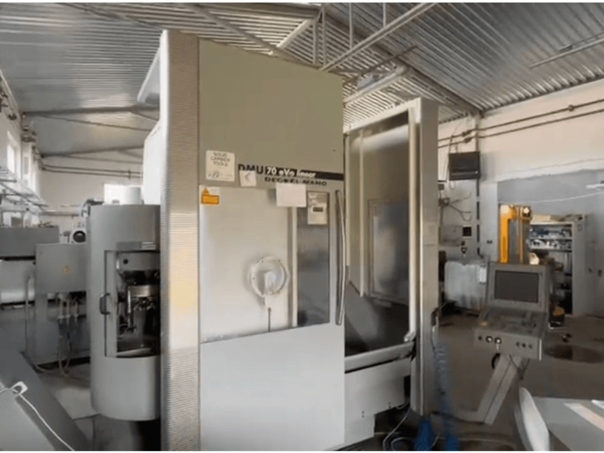 Лінійний верстат з ЧПК DMU 70 eVo в майстерні, вид спереду, з панеллю керування та сучасним дизайном.