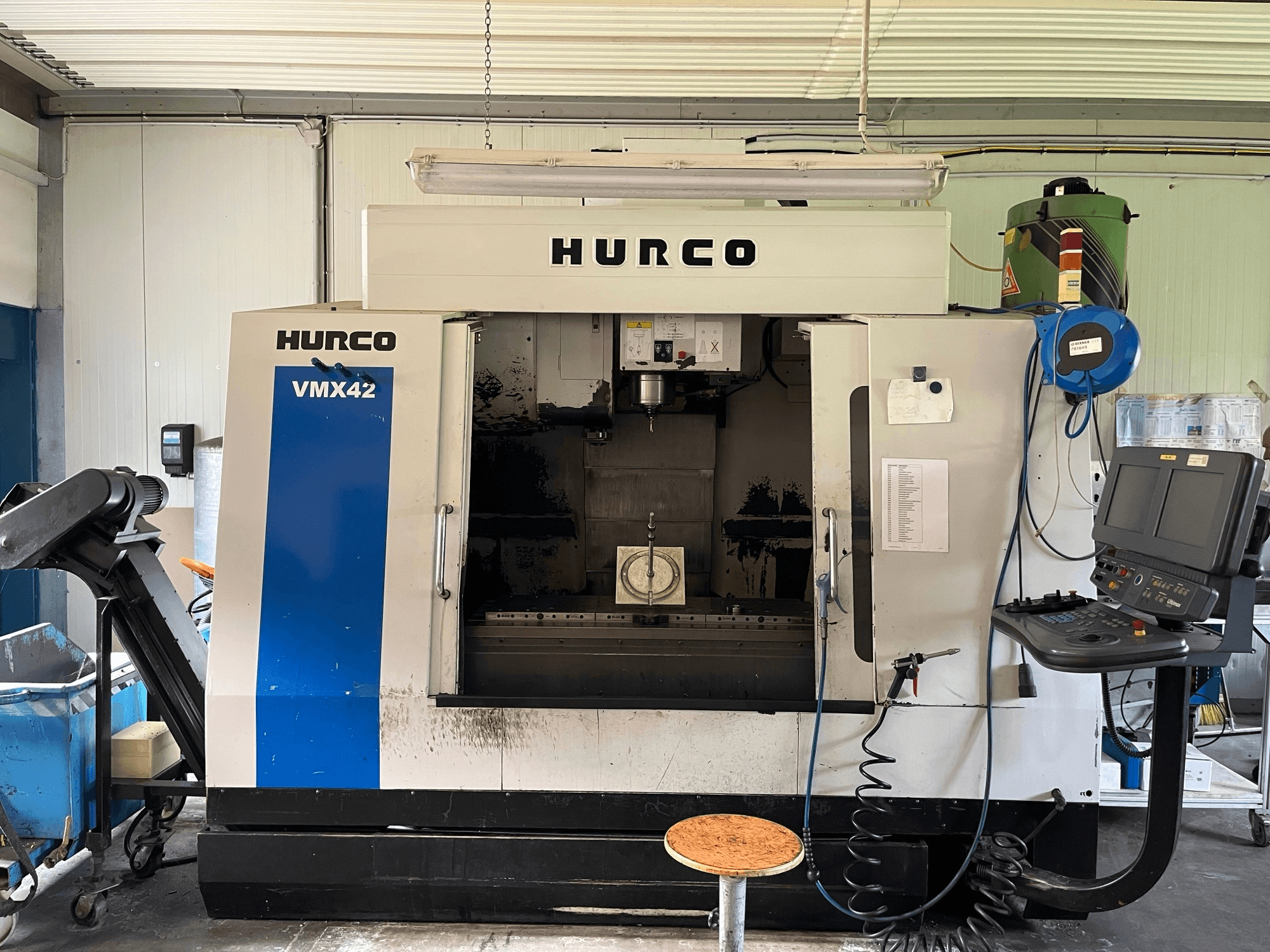 Вертикальний обробний центр Hurco VMX 42 у вигляді збоку, з панеллю керування, шпинделем та налаштуванням заготовки.