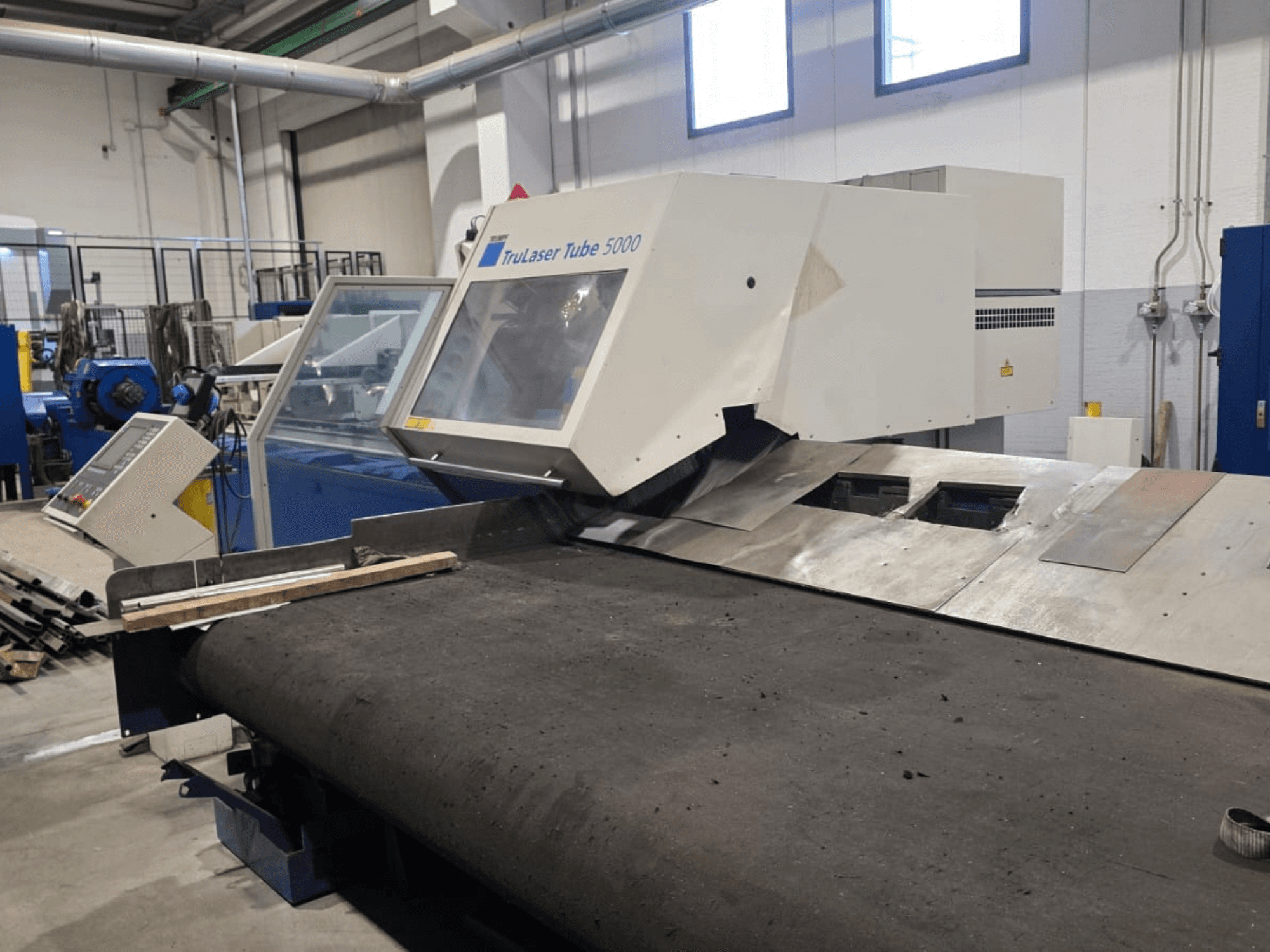 Машина для різання труб TRUMPF LASERTUBE 5000, вид спереду, на якому видно зону різання та панель керування.