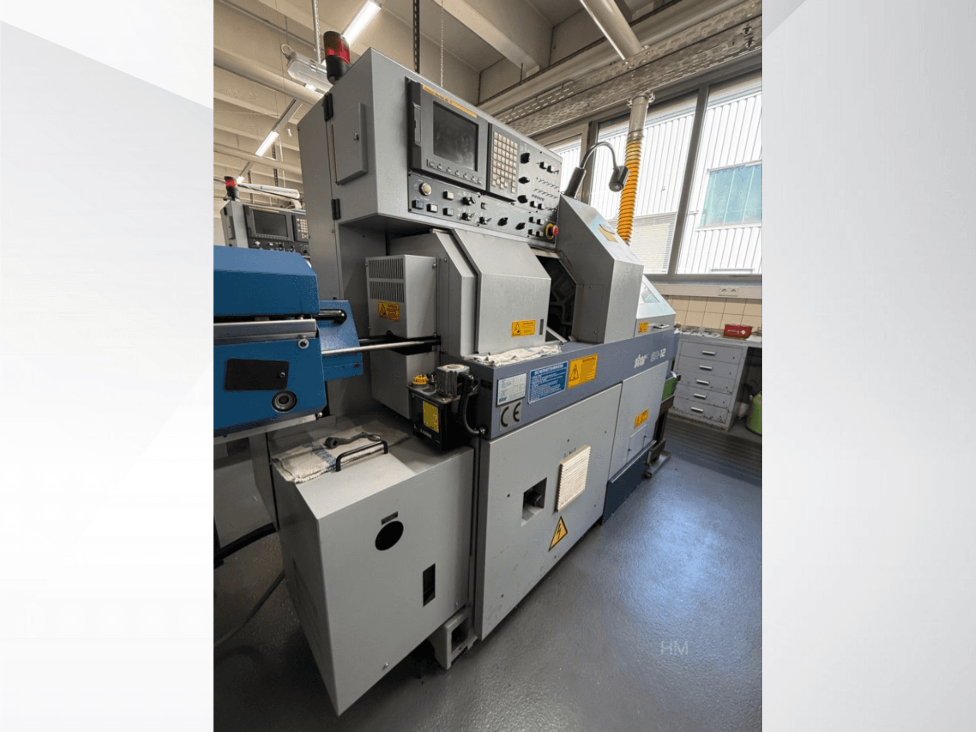 Вид спереду машини lithec 3231, з панеллю керування, двигуном і синьою секцією подачі в добре освітленому промисловому приміщенні.